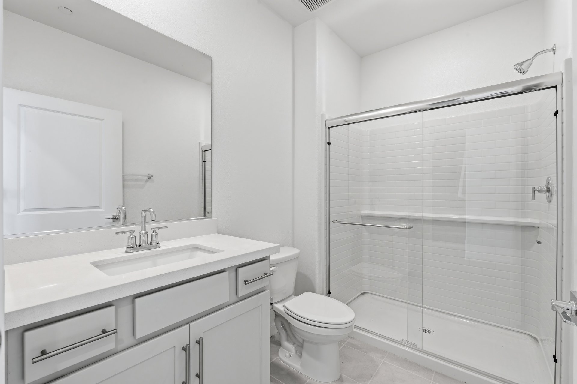 bathroom with white cabinets & counter, chrome faucet, and walk-in shower