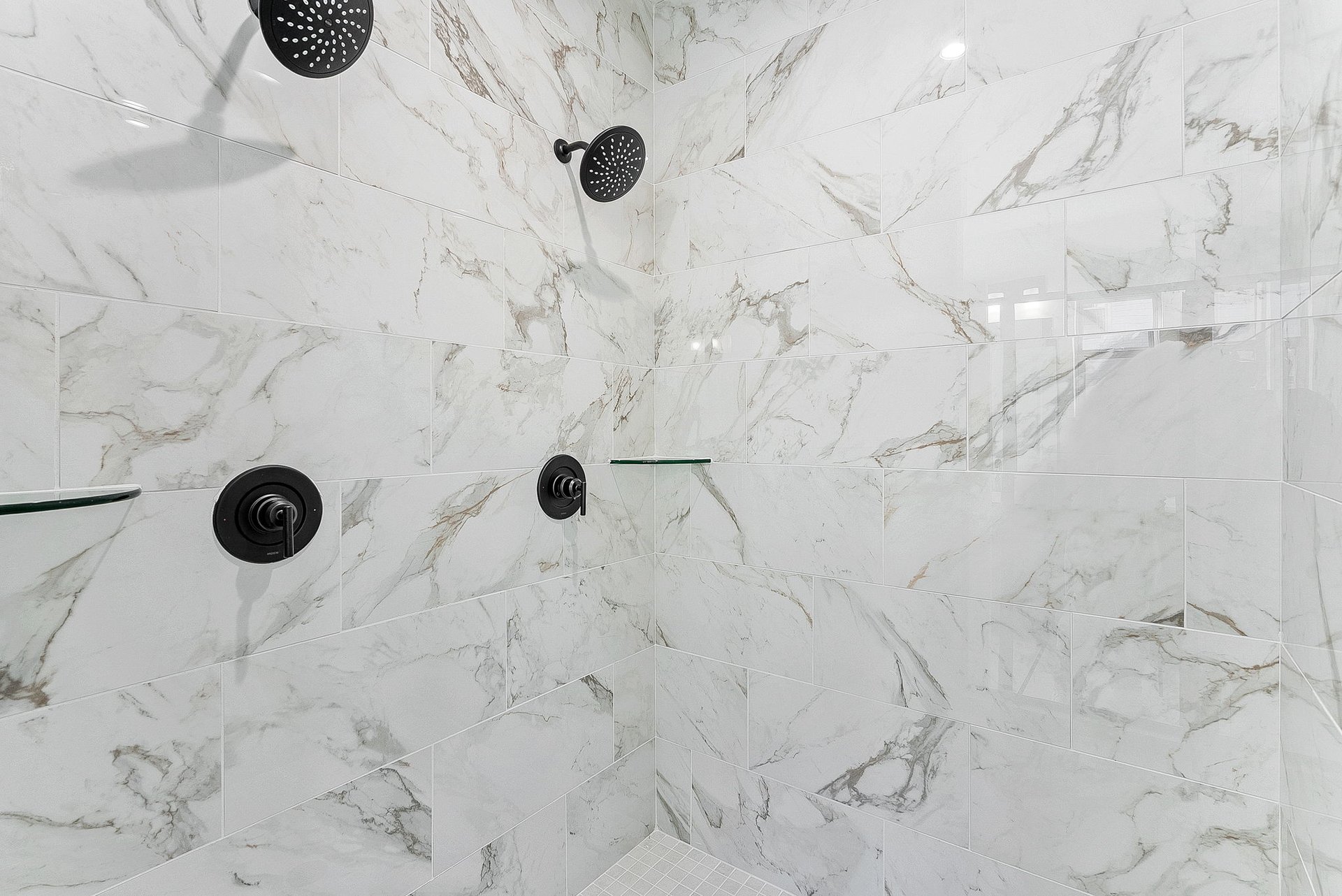 primary bathroom with an oversized shower and marble tile
