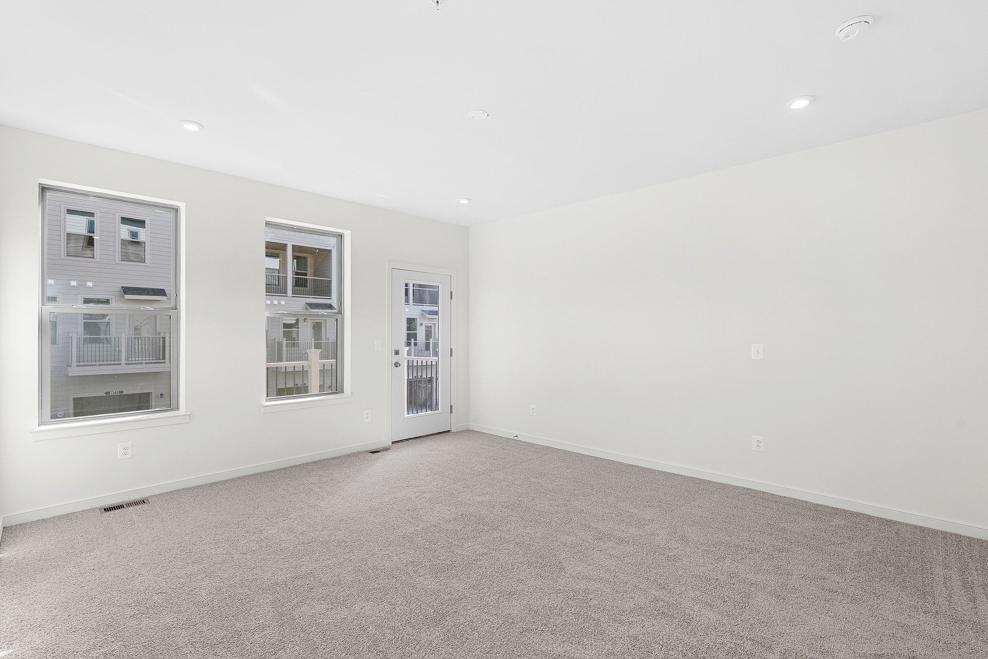 primary bedroom with multiple windows and carpet