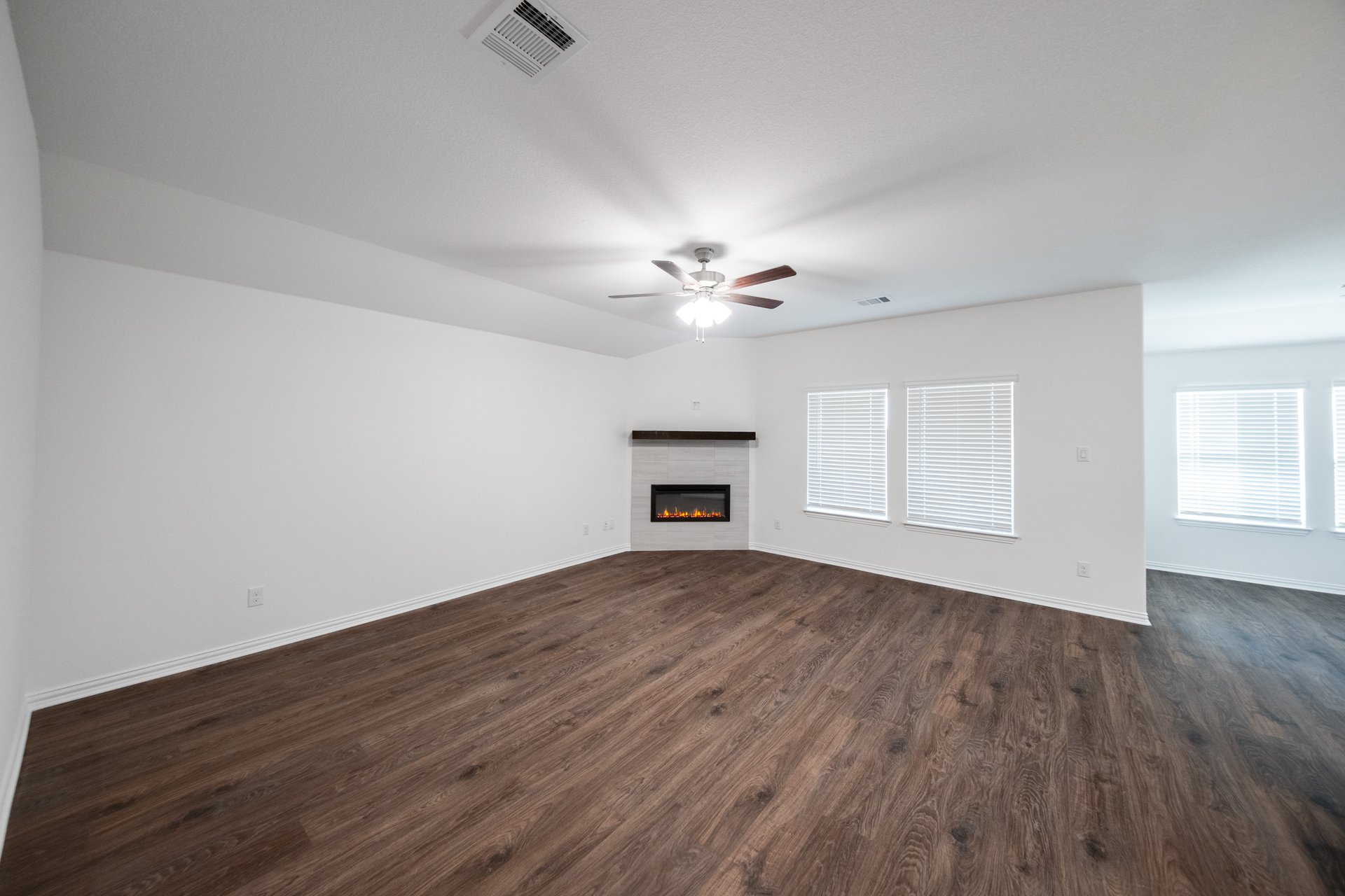 open great room with wood floors and fireplace