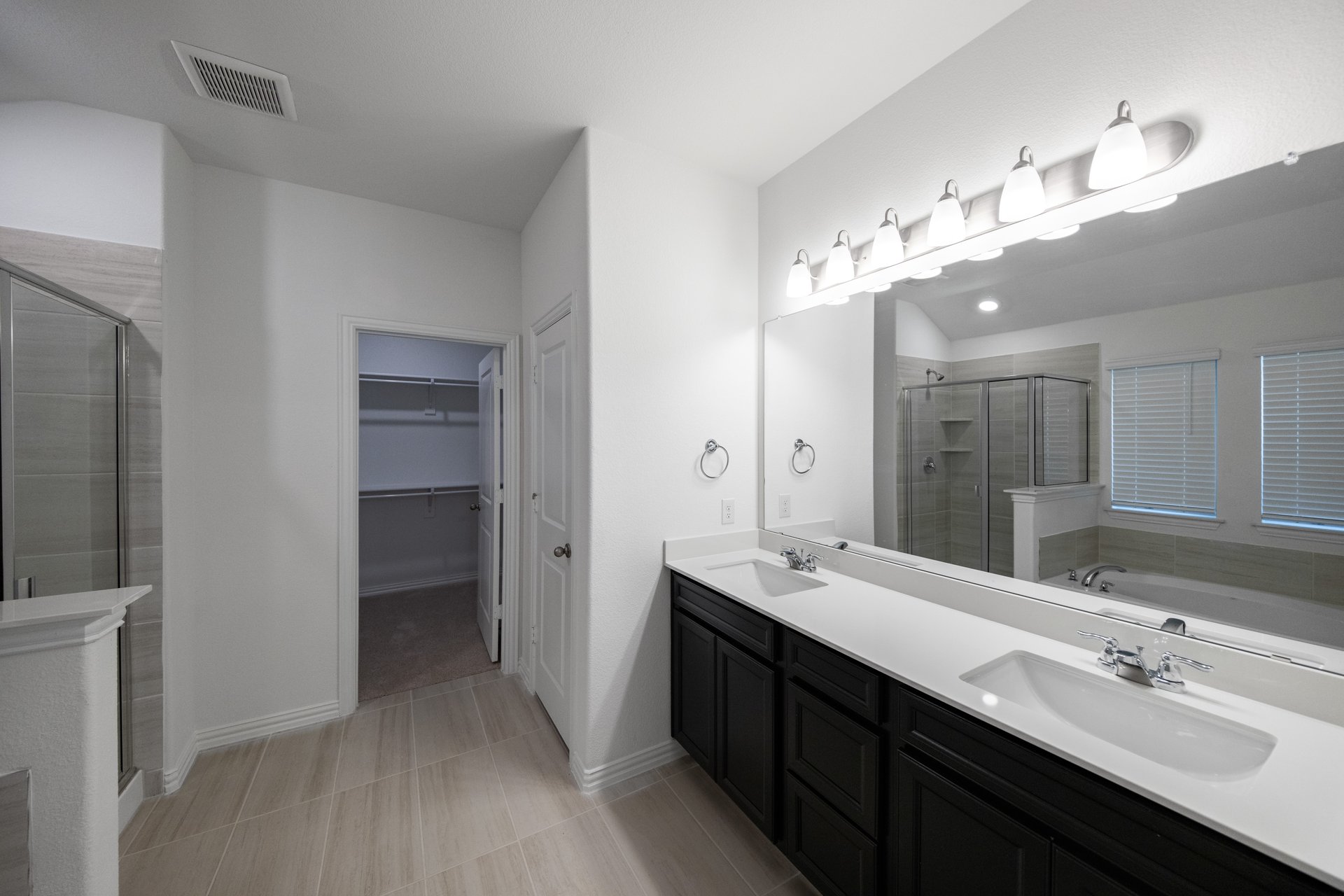 primary bathroom with two sinks and tile floors 