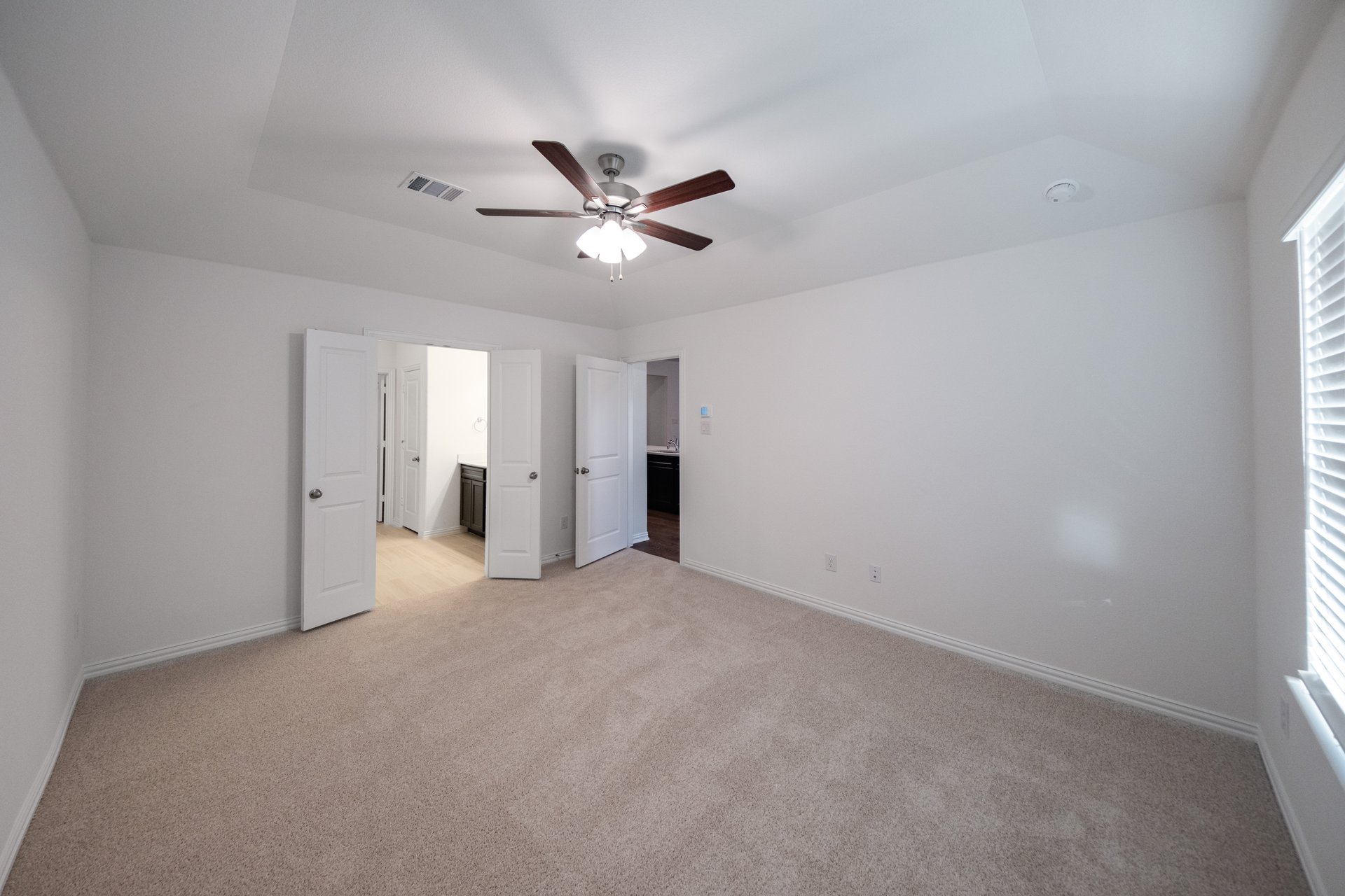 primary bedroom with carpet and ceiling fan
