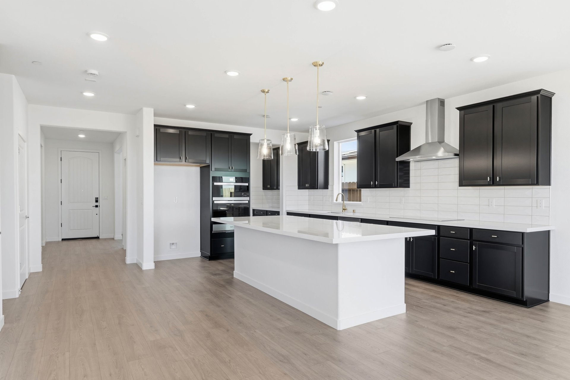kitchen with espresso cabinets, white quartz counters, wood floors, and island