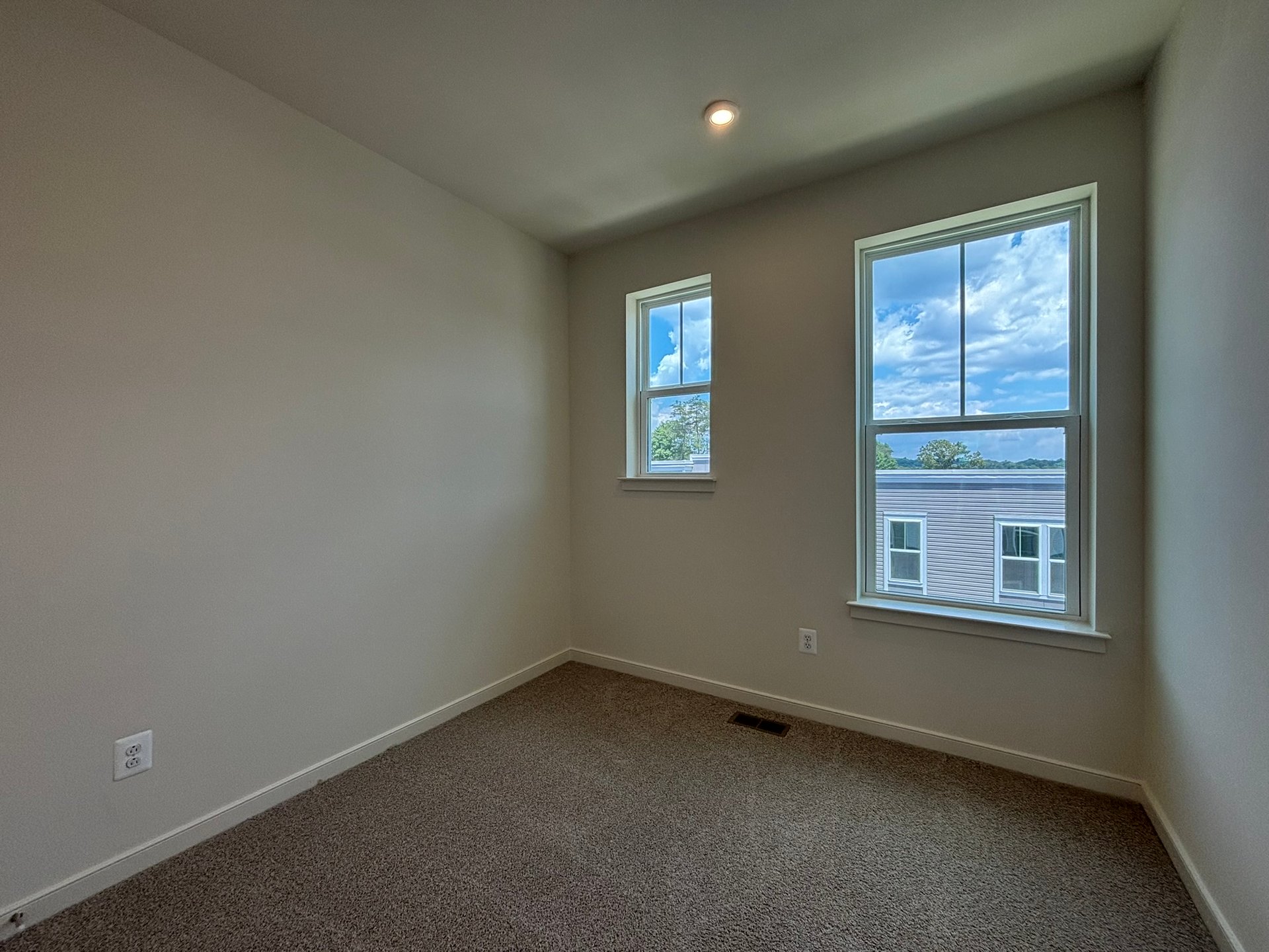 secondary bedroom with carpet and two windows