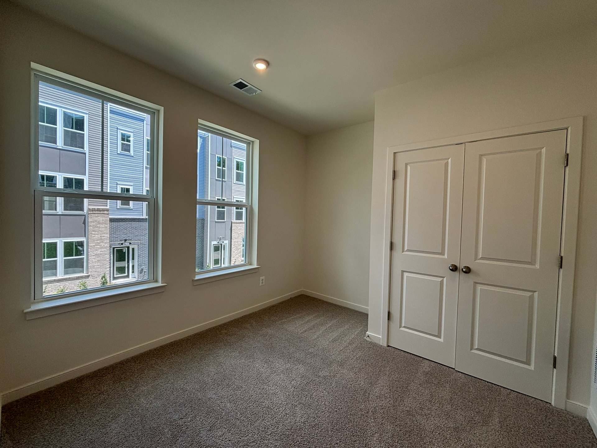 secondary bedroom with carpet and two windows