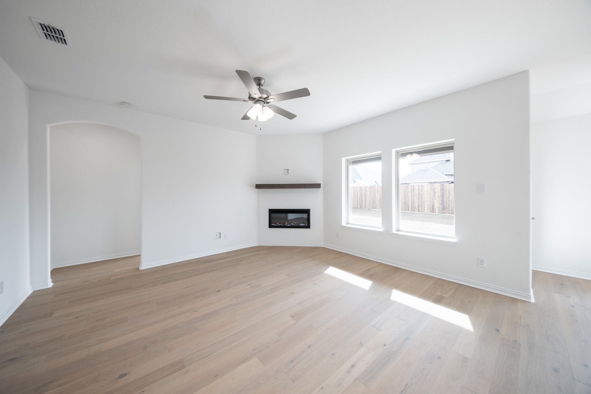 open great room with wood floors and fireplace