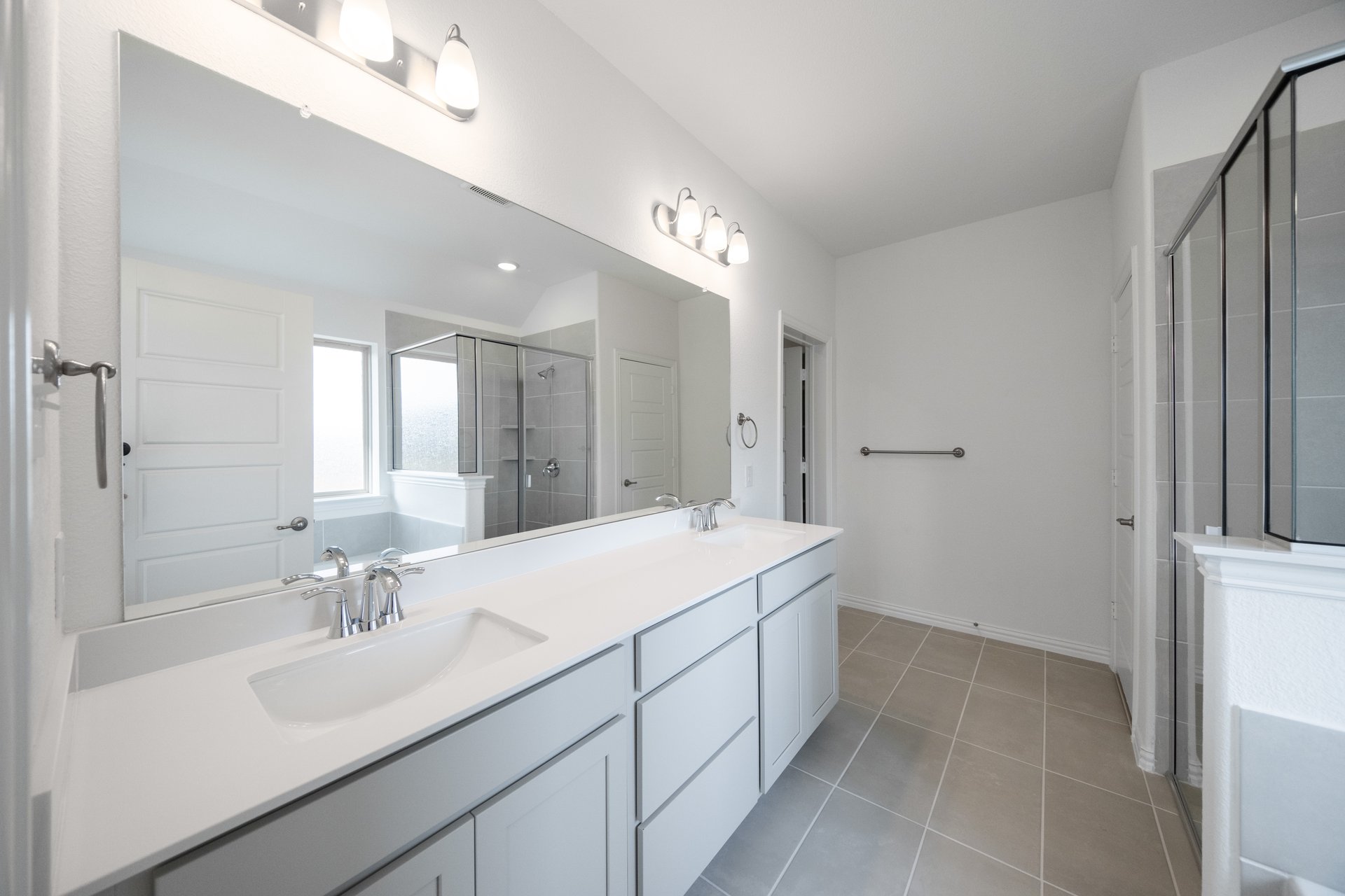 primary bathroom with two sinks and tile floors