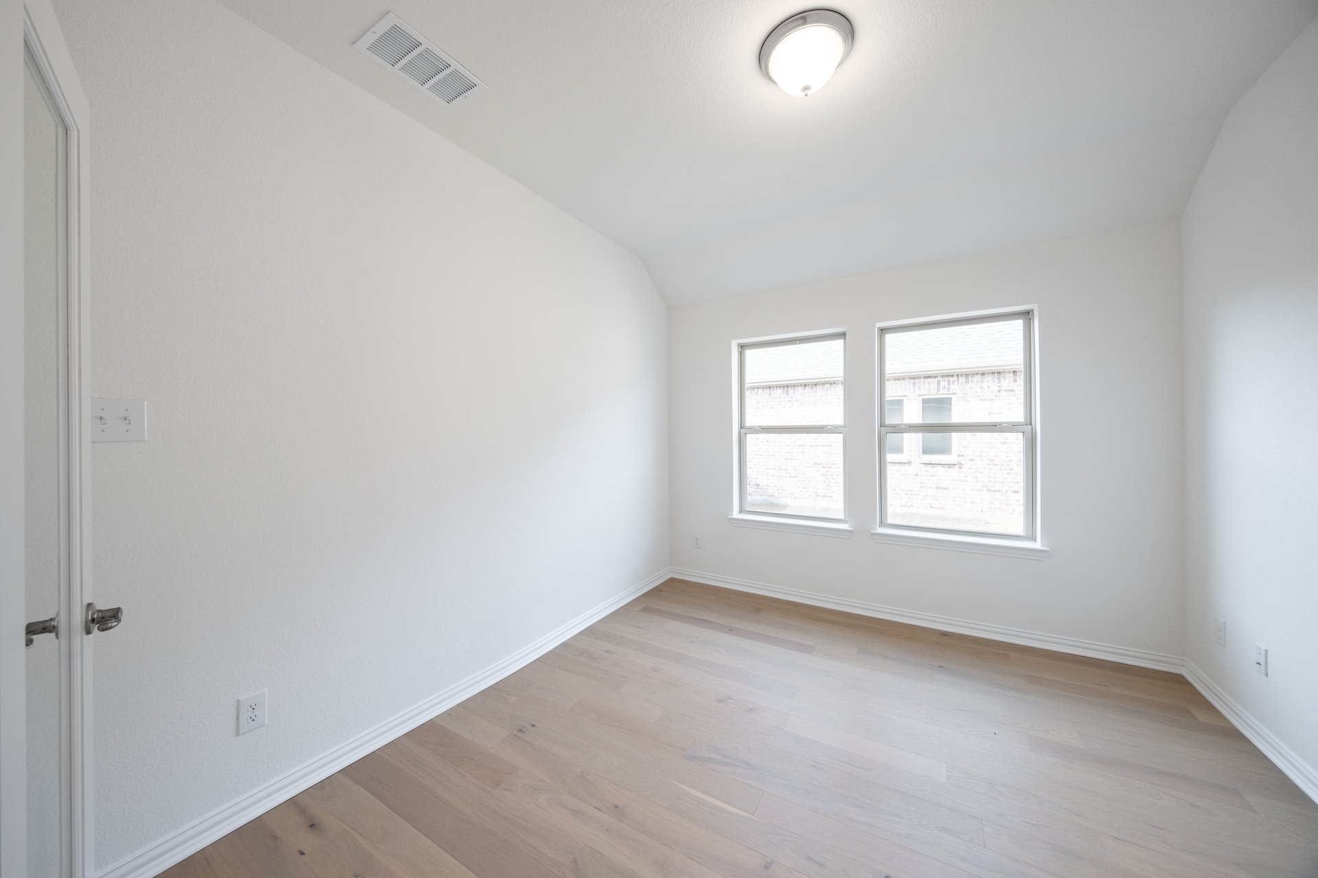 private study with wood floors and windows