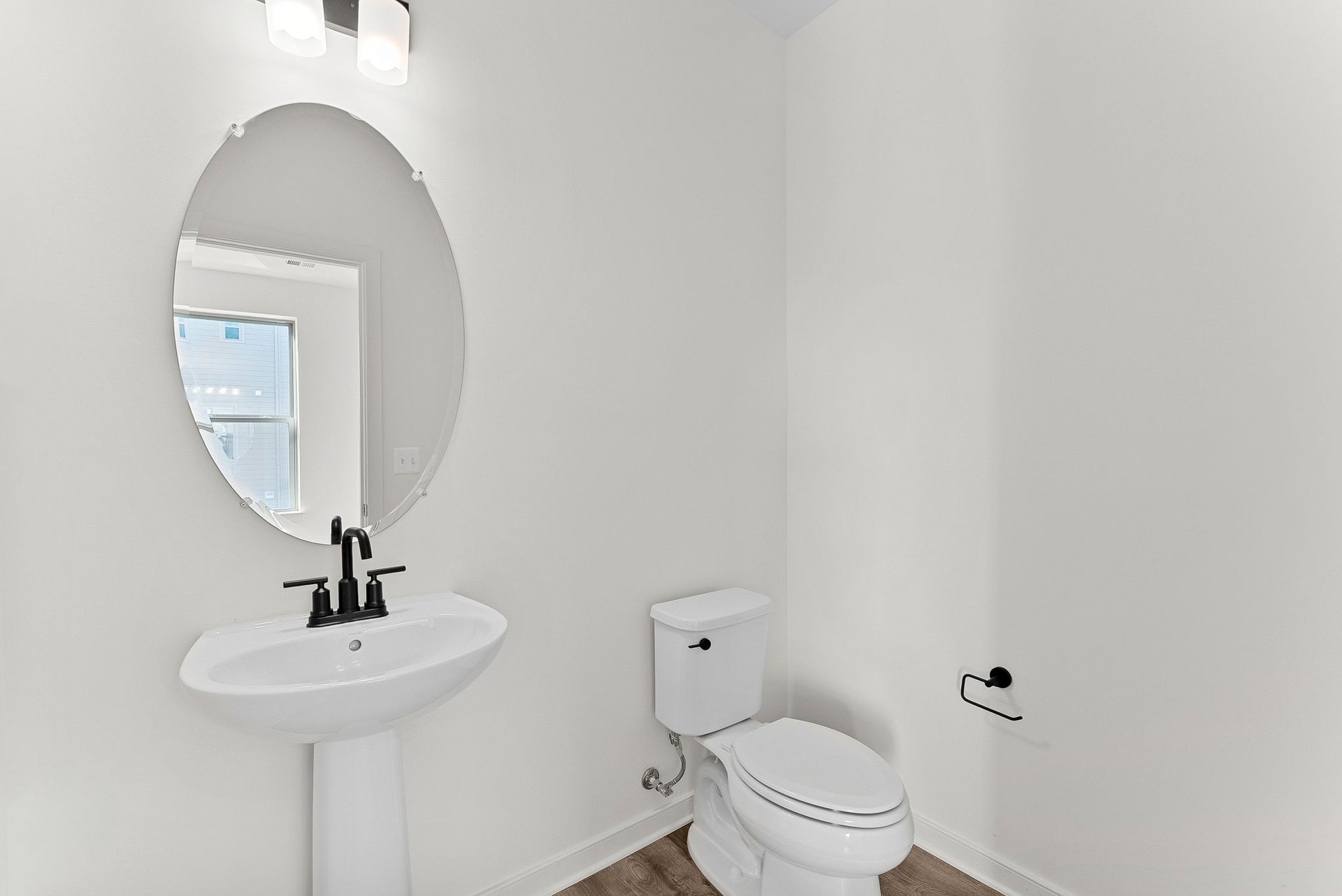 powder room with pedestal sink and a mirror