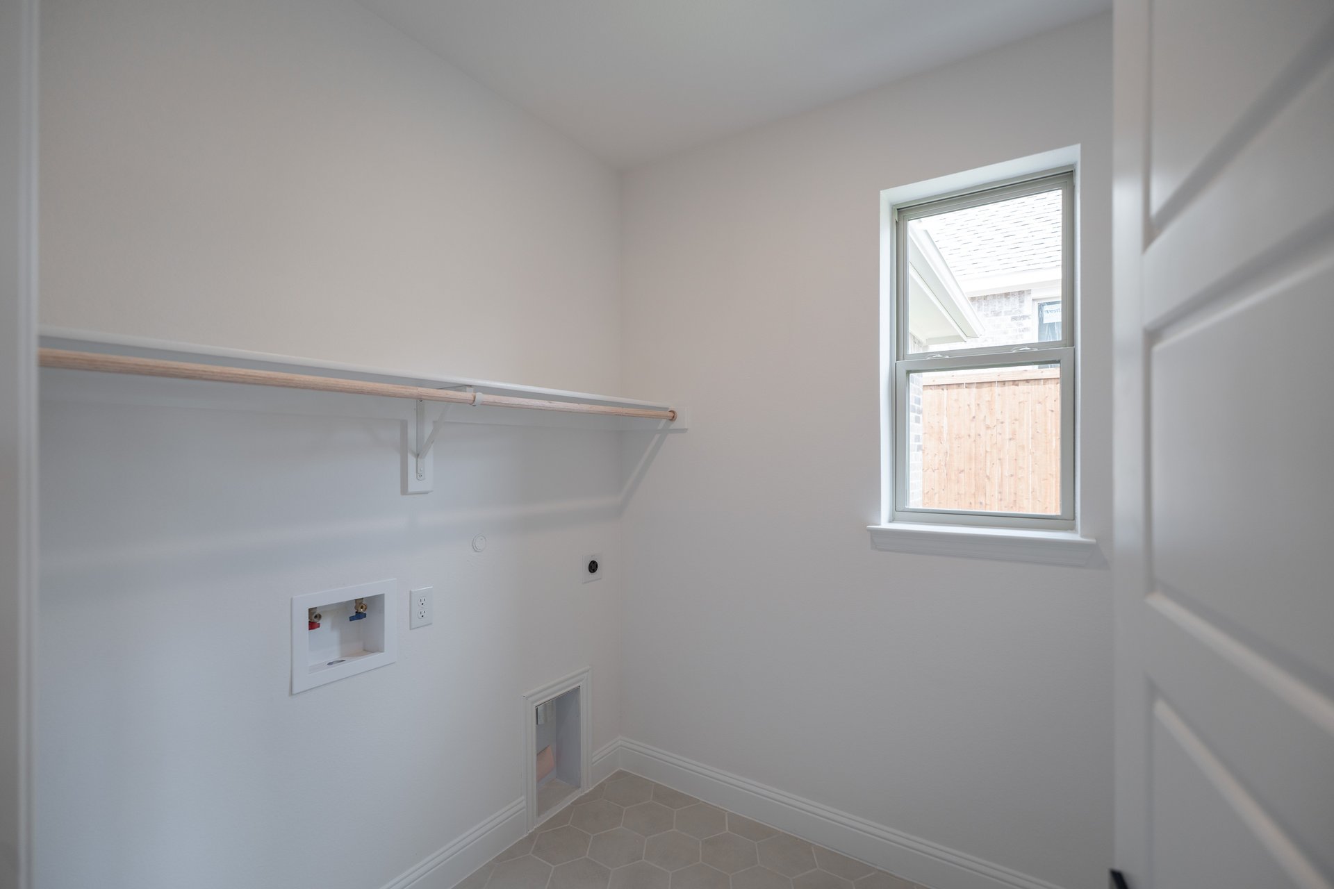 laundry room with tile floors and white shelf