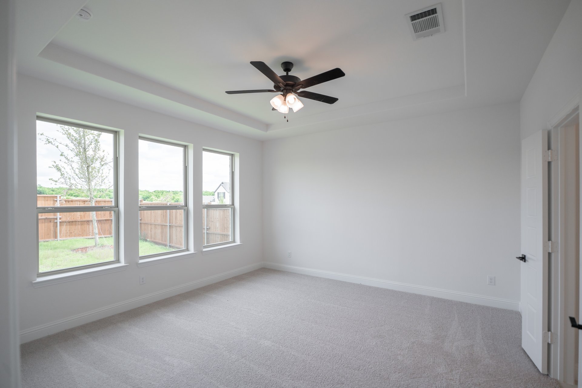 primary bedroom with carpet and ceiling fan