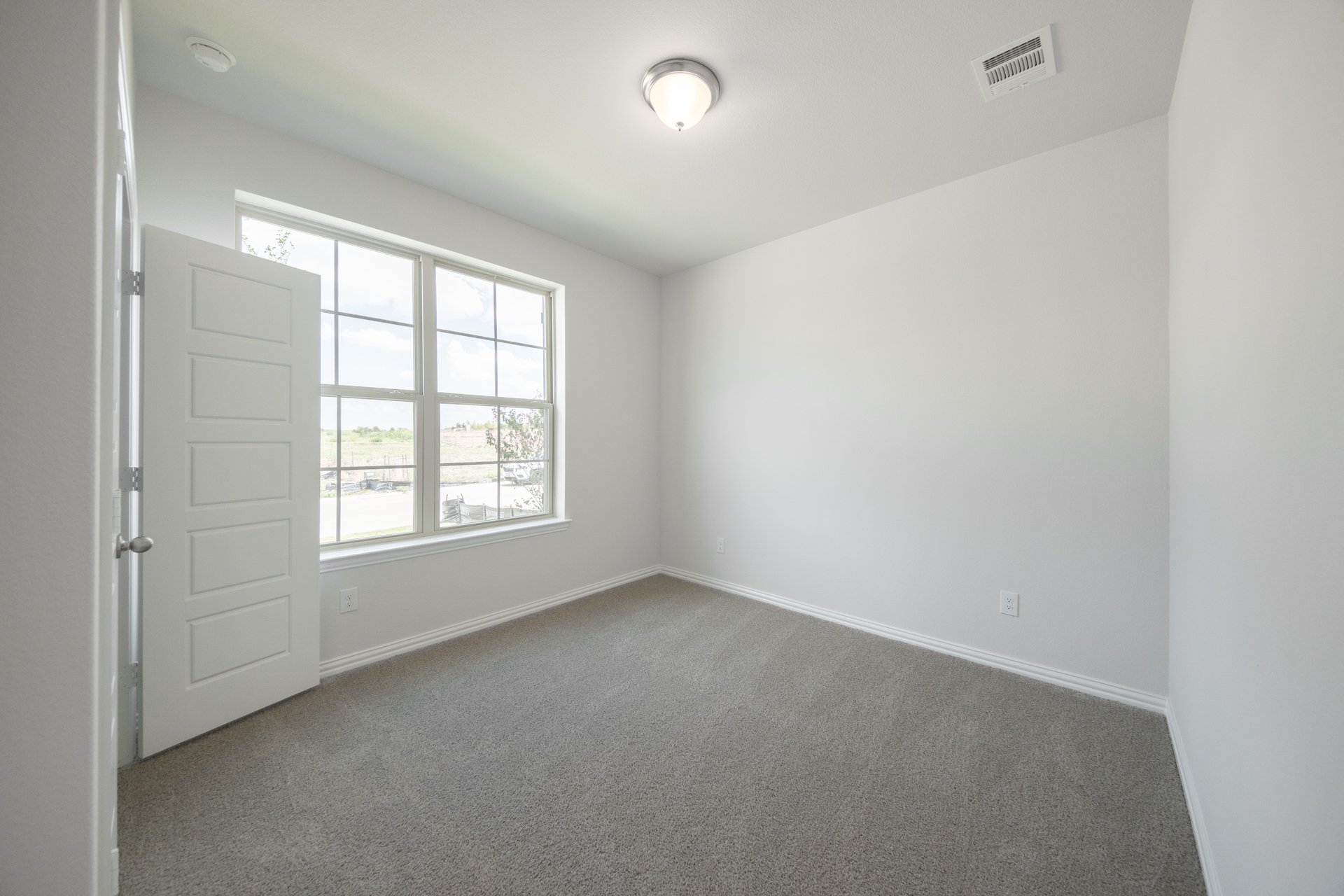 guest bedroom with carpet and window