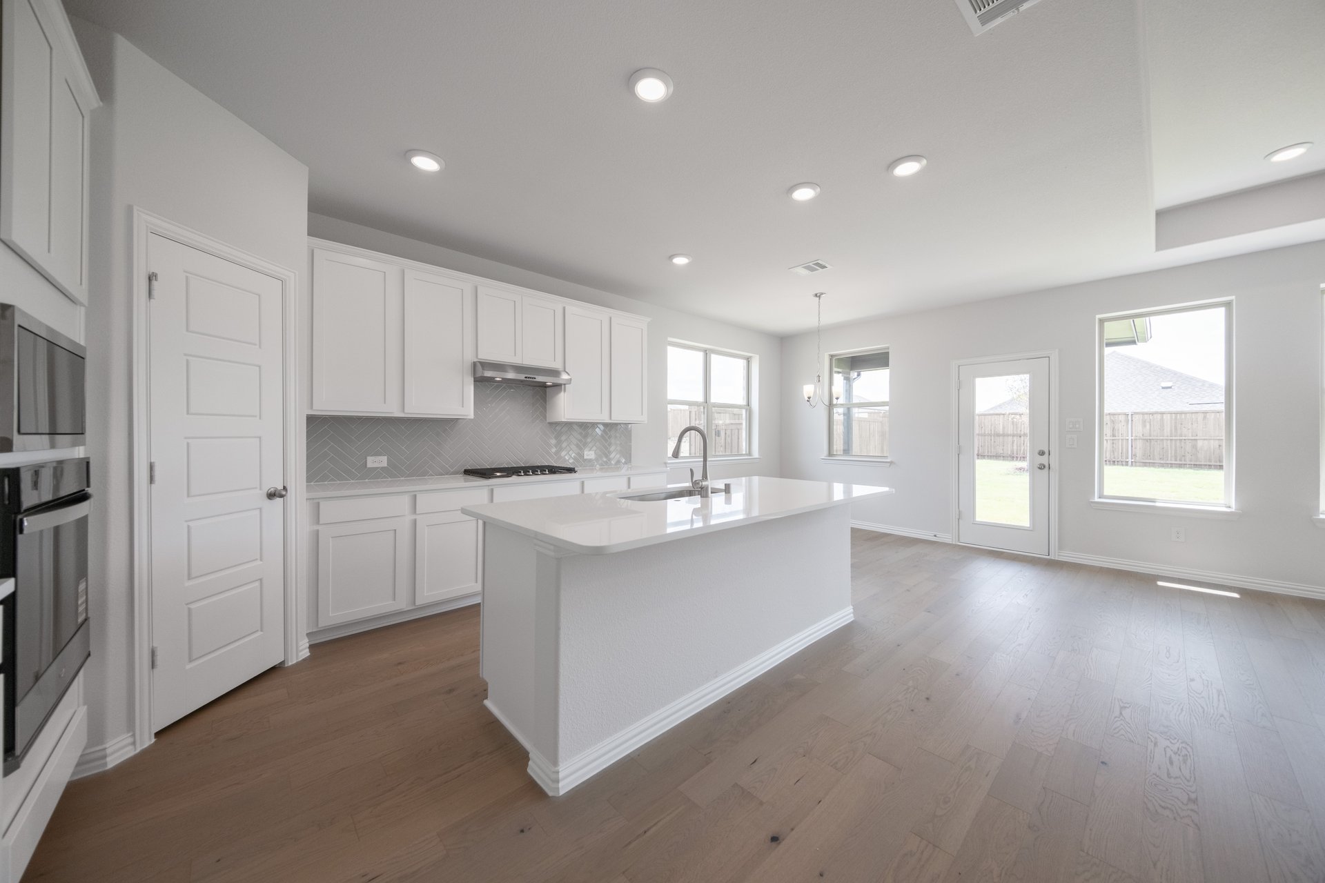 open kitchen with white cabinets and hardwood flooring