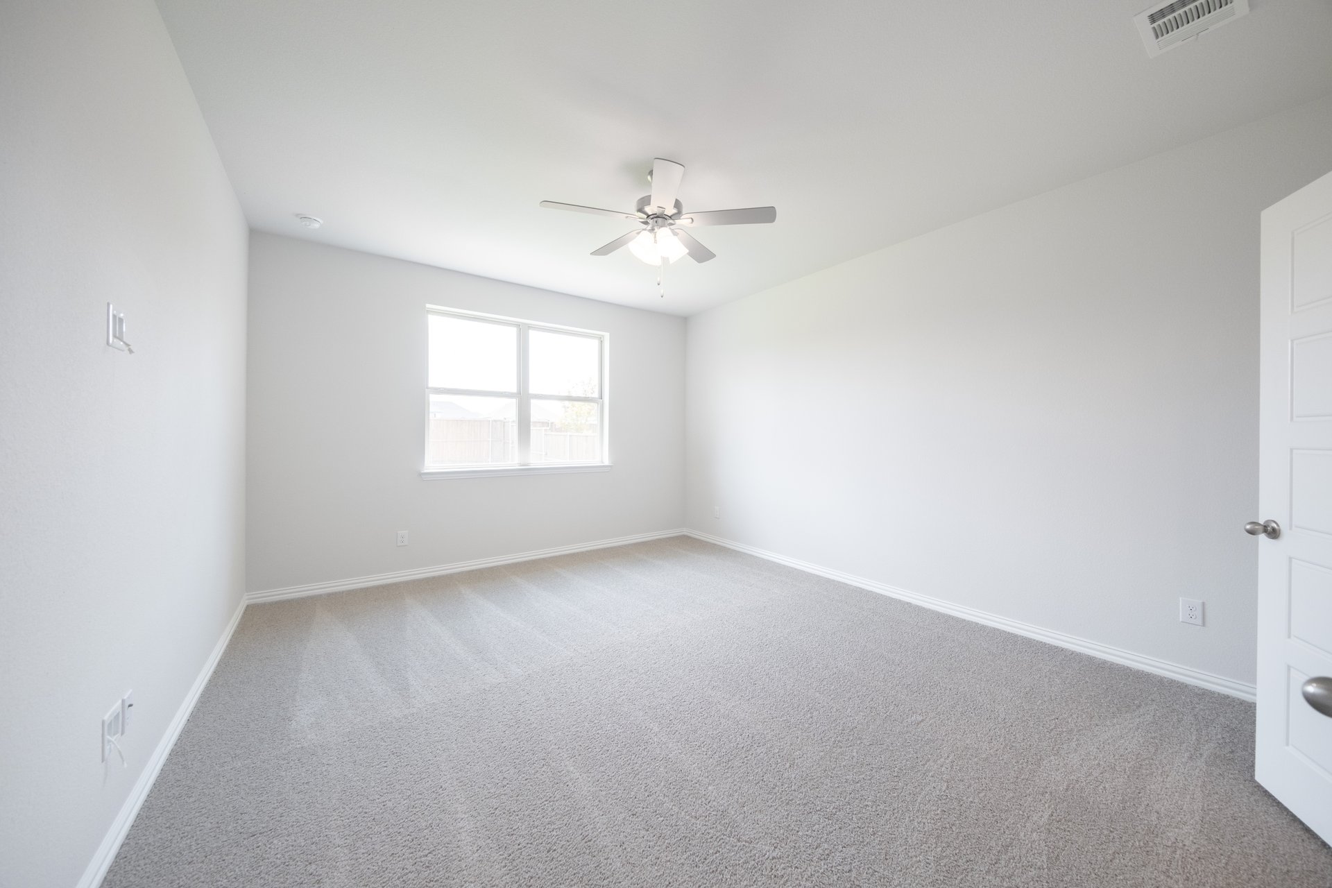 spacious primary bedroom with carpet and windows
