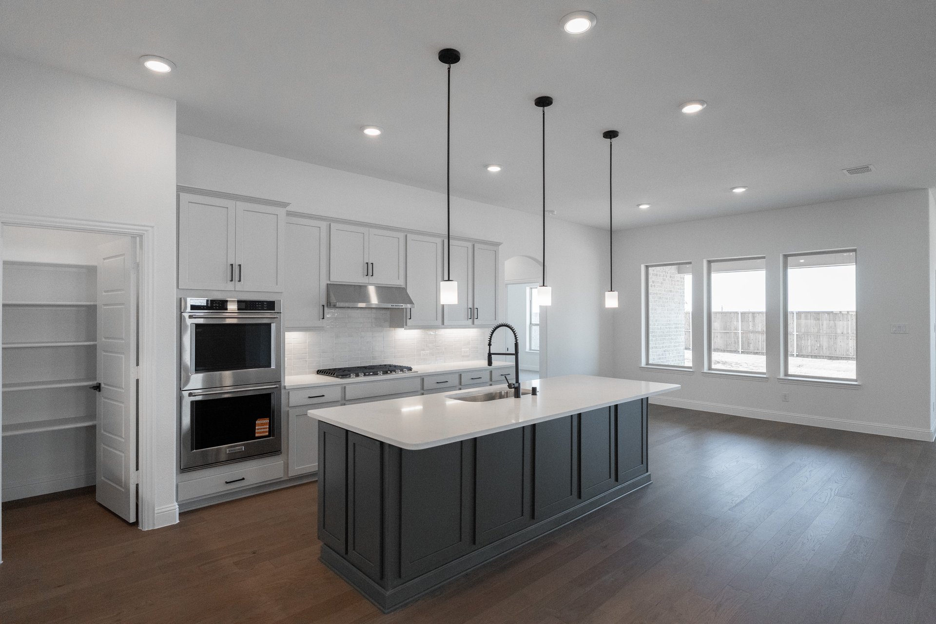 open kitchen with white cabinets and hardwood flooring