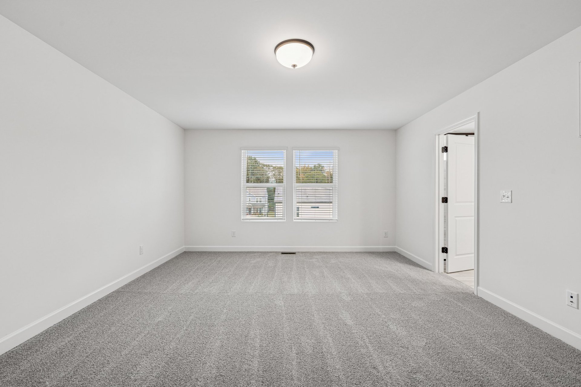 primary bedroom with windows and access to bathroom