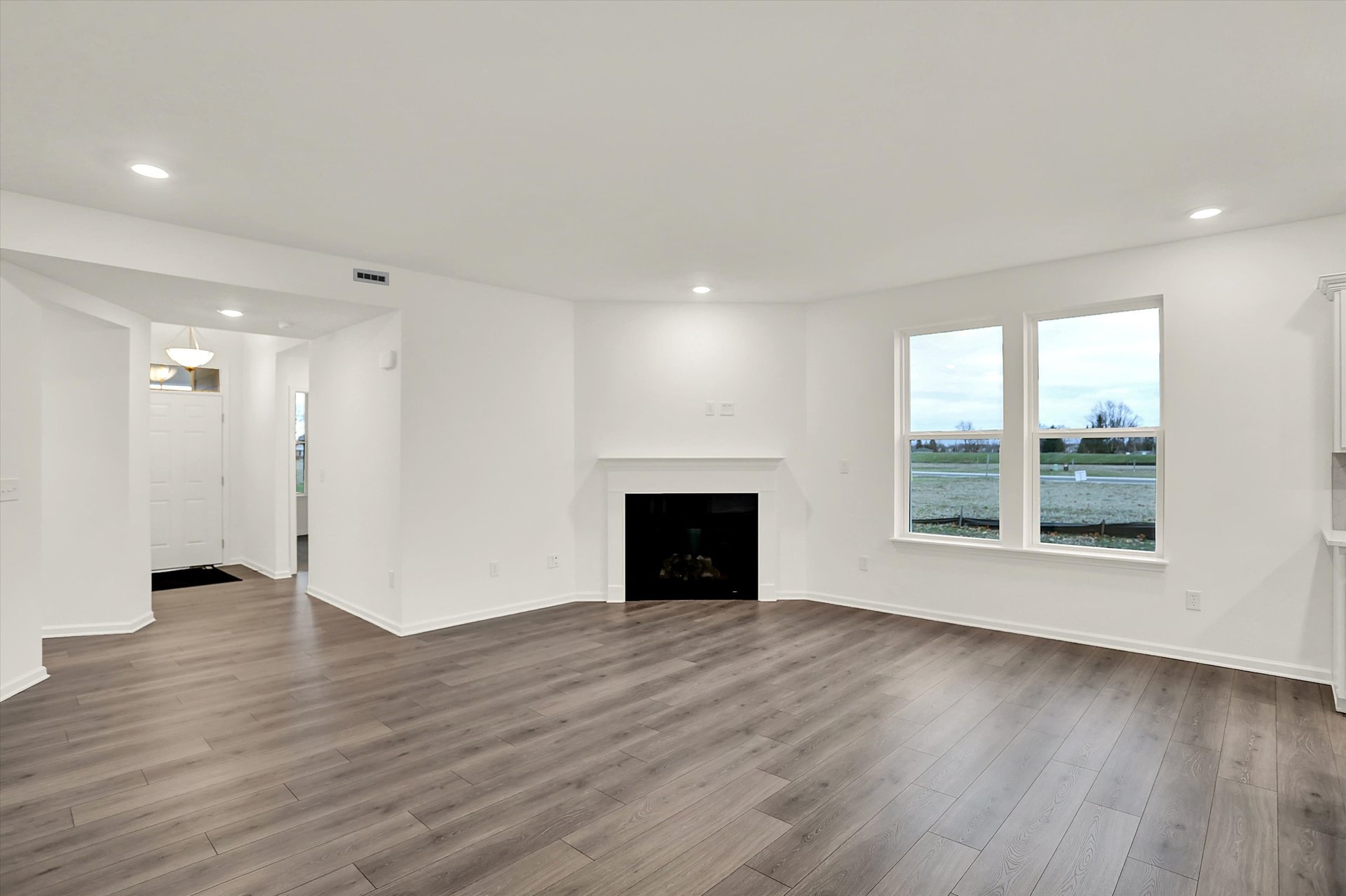 great room with plank flooring and fireplace