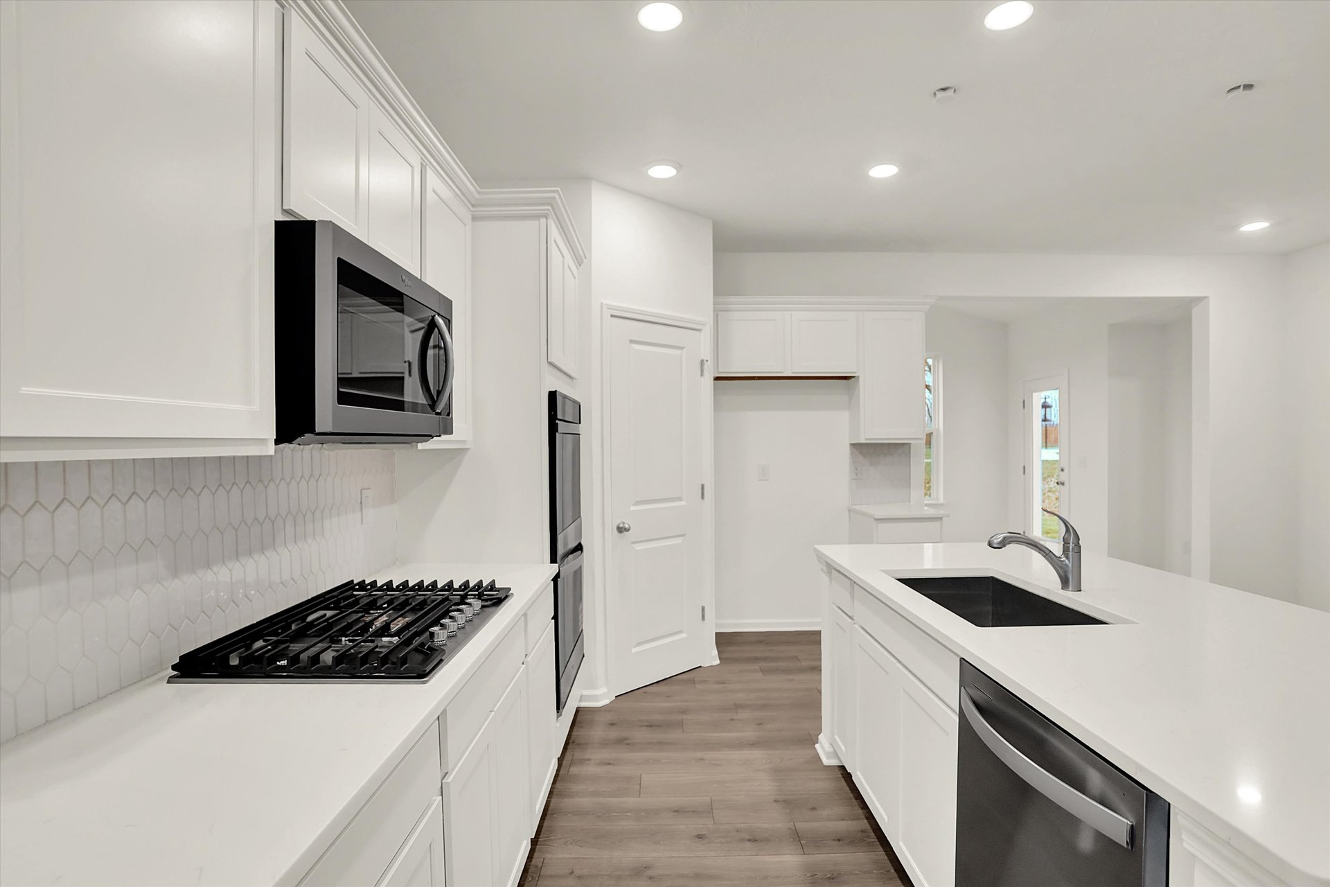 kitchen with white cabinets and countertops with a gray backsplash