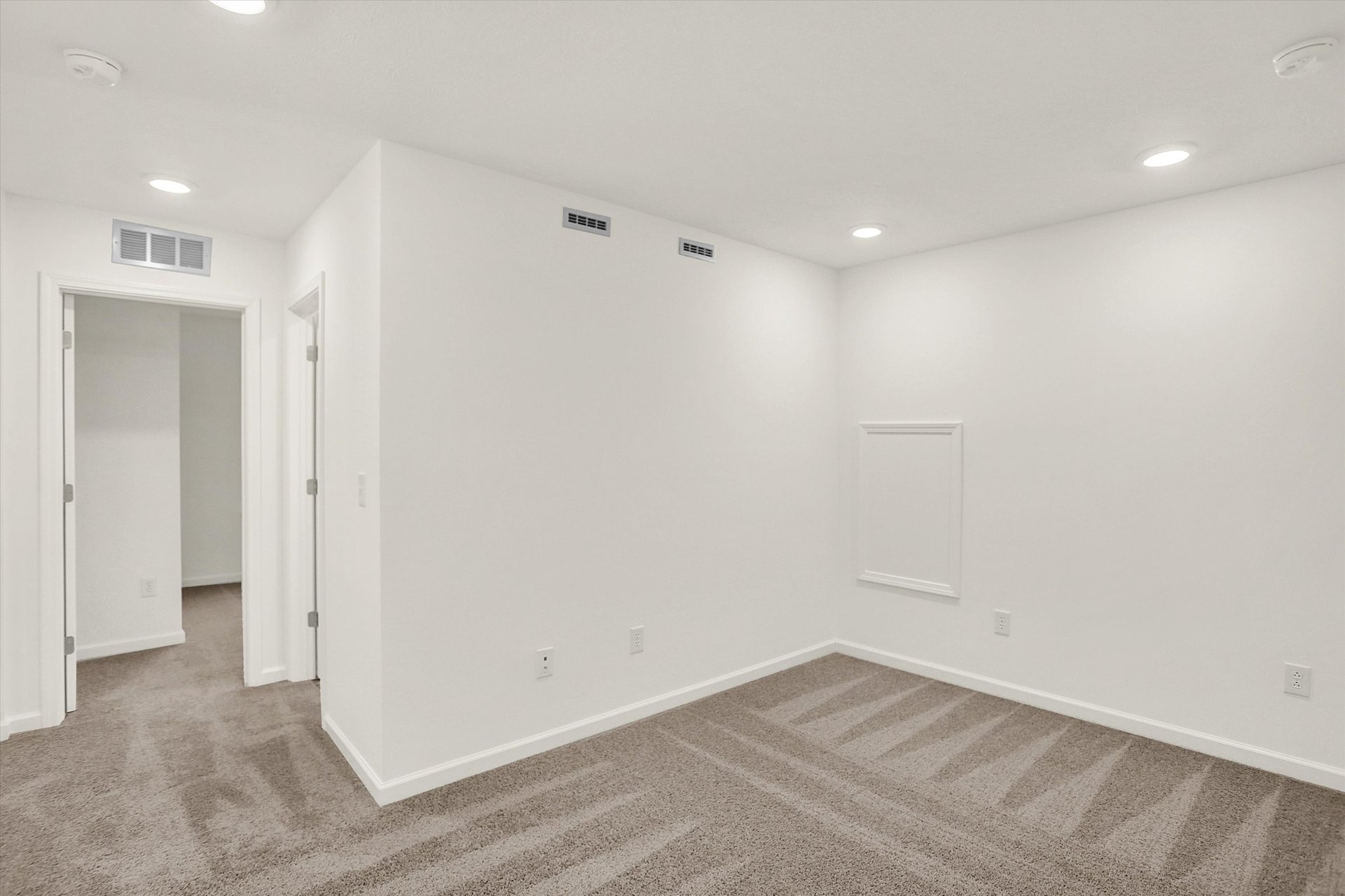 loft with tan carpets and whtie walls