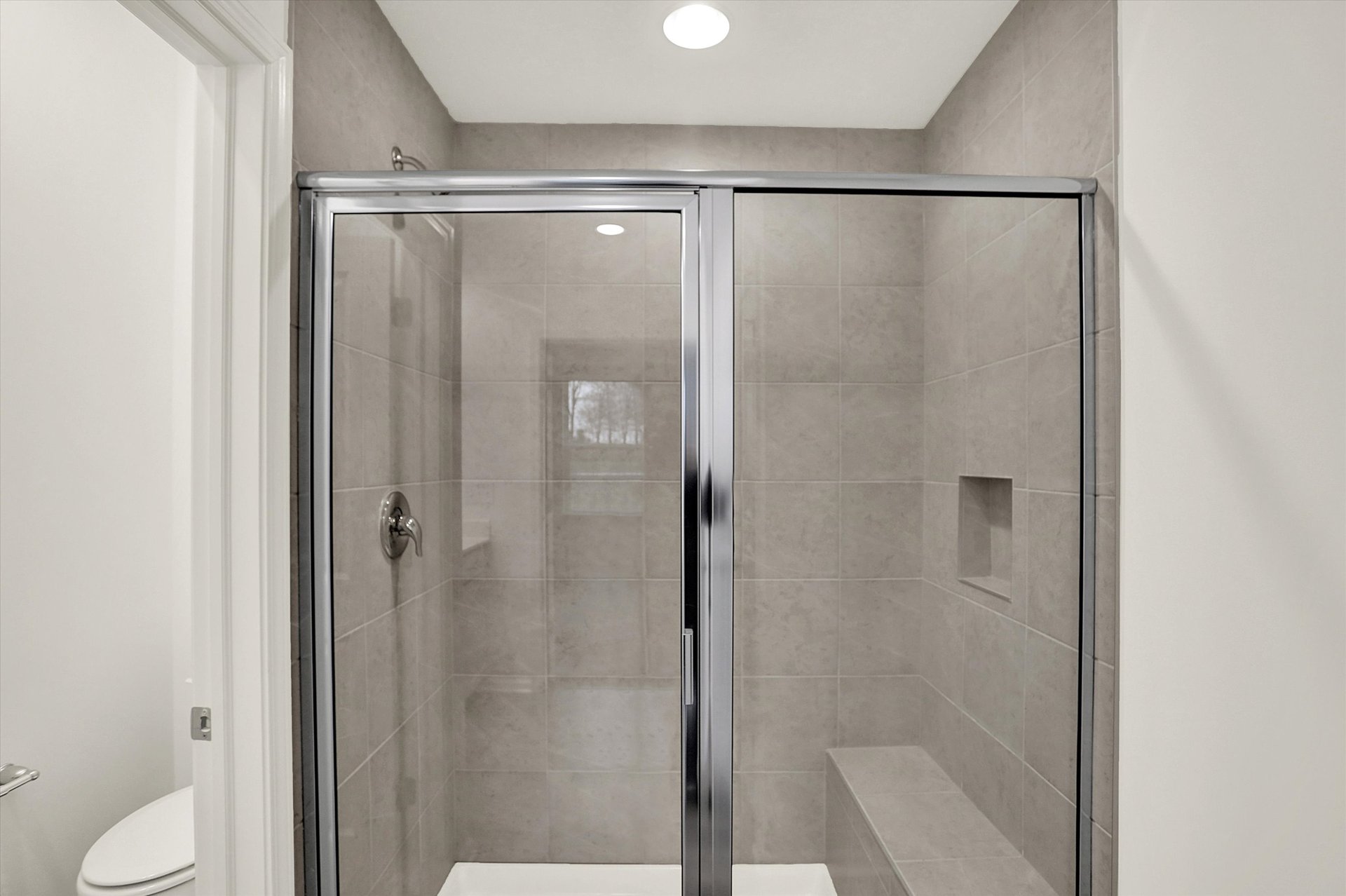 bathroom with tile walk-in shower that has a bench
