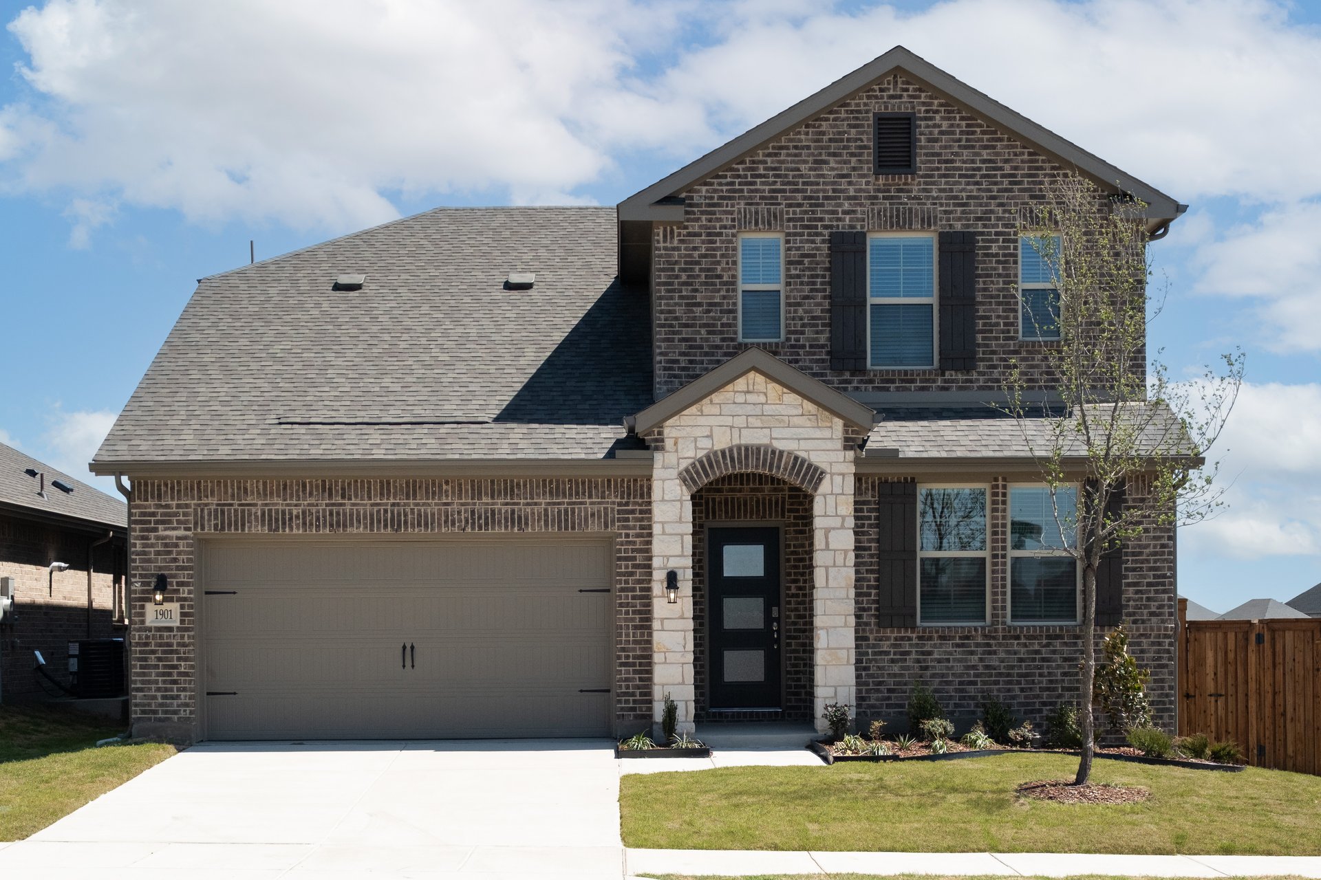 exterior of home with brown brick and white stone