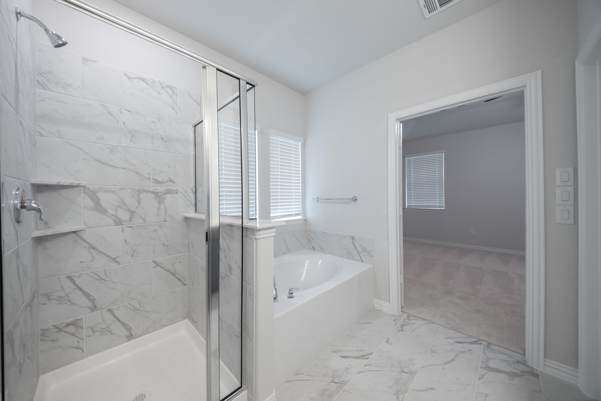 primary bathroom with separate soaking tub and walk-in shower