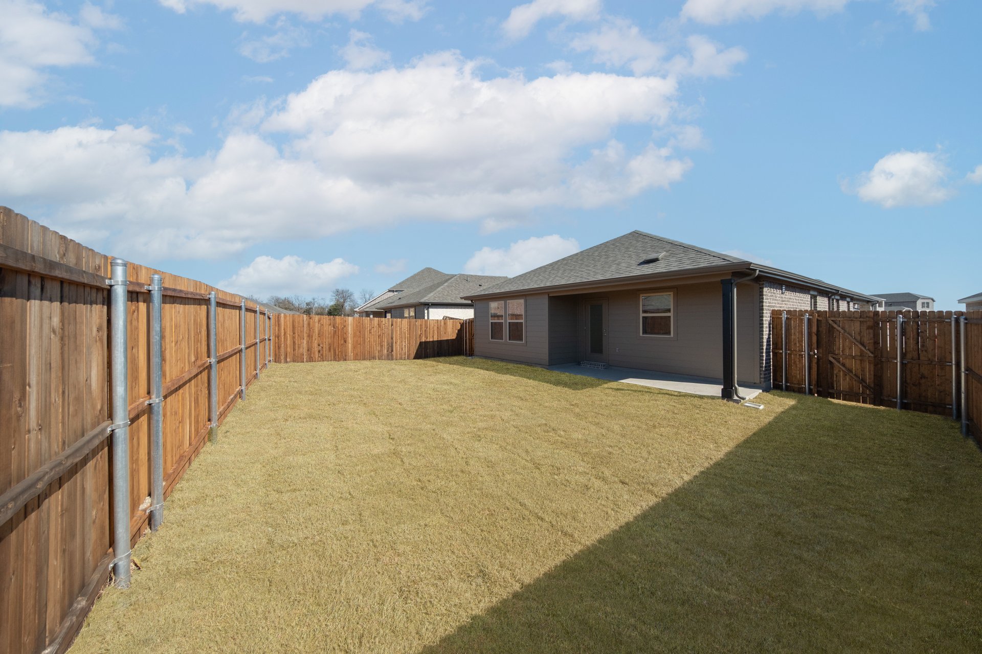 covered patio that opens to fenced backyard 