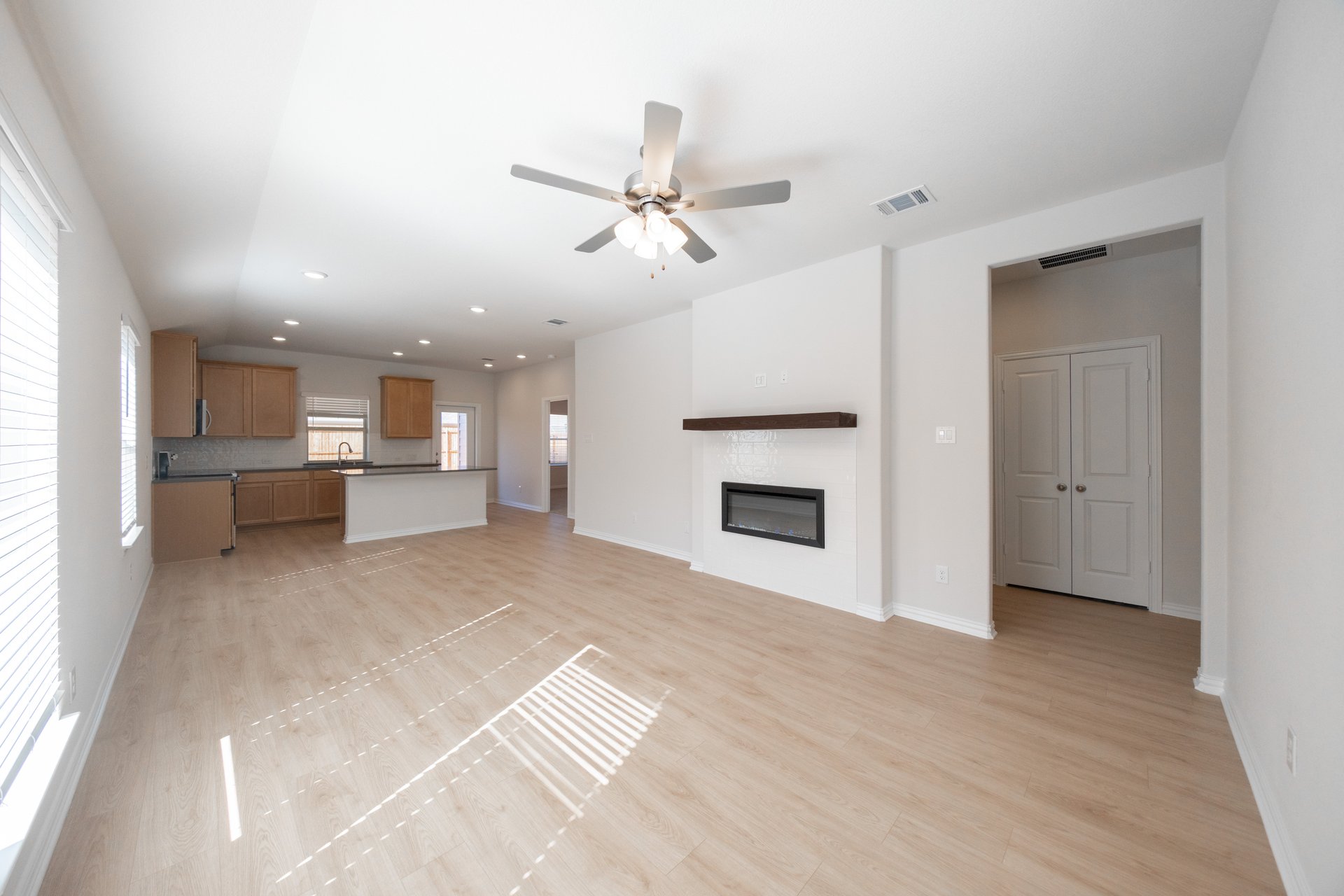 great room with fireplace and wood floors 