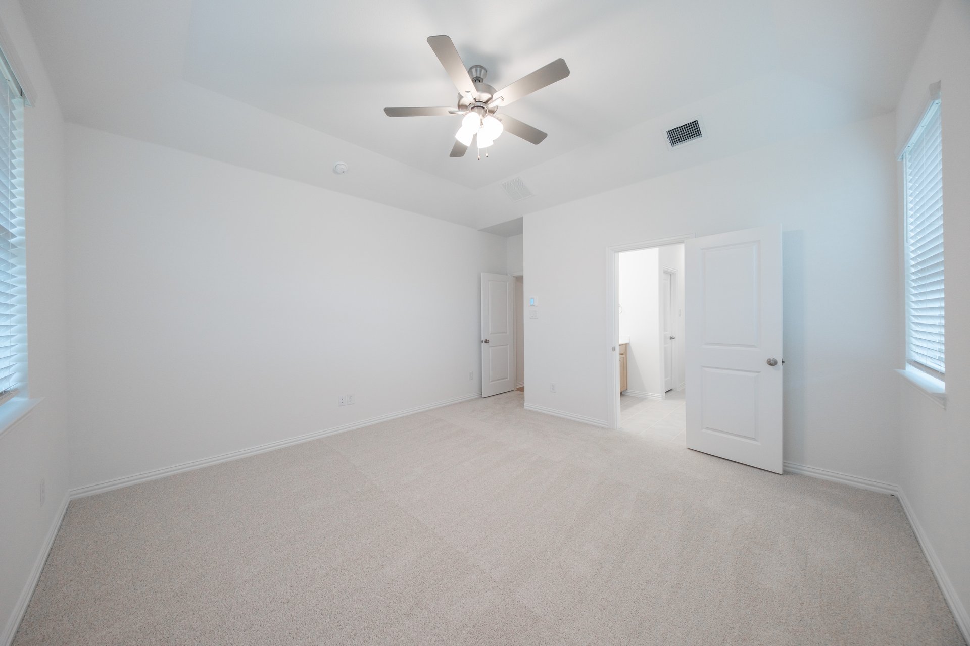 primary bedroom with carpet and ceiling fan