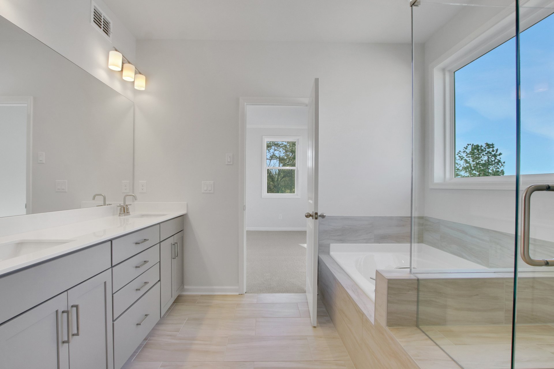 primary bathroom with gray cabinets and tile flooring