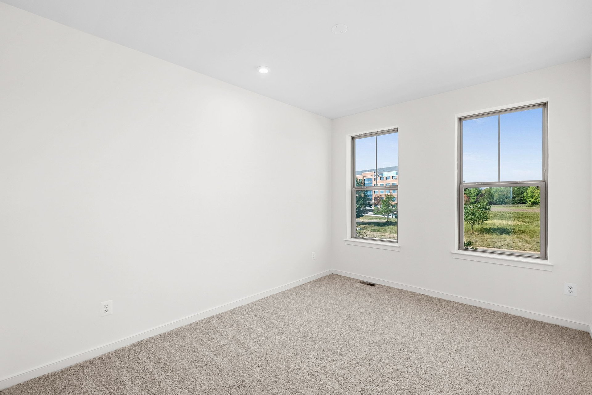 secondary bedroom with carpet and two windows