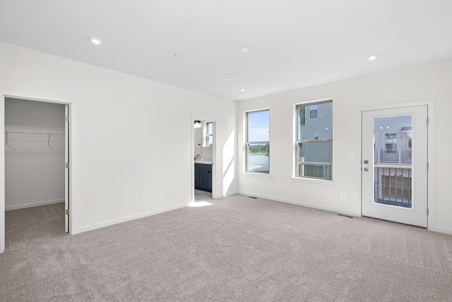 primary bedroom with multiple windows and carpet
