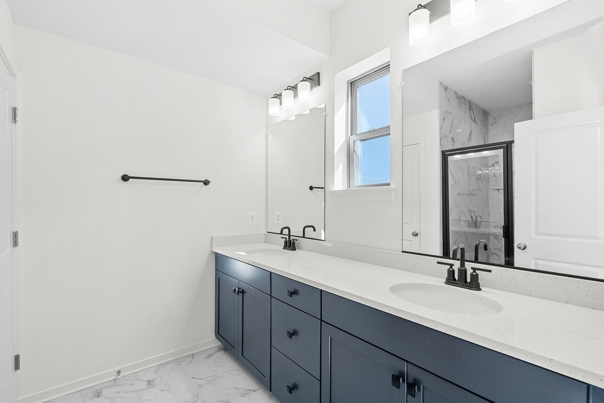 primary bathroom with two sinks and an oversized shower