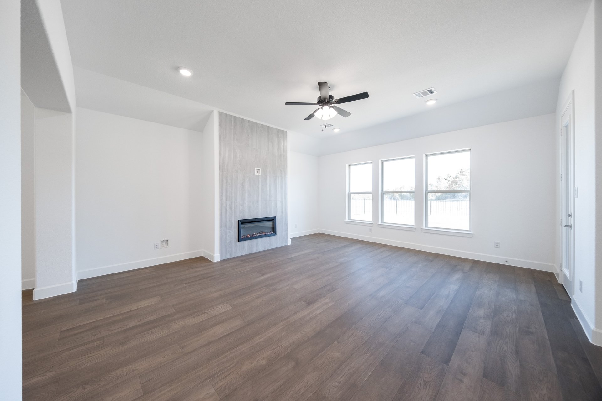 great room with wood flooring and fireplace 