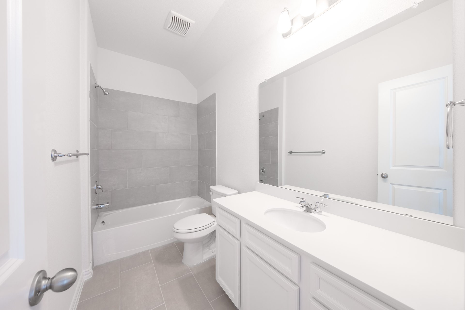 bathroom with white countertops and tile 