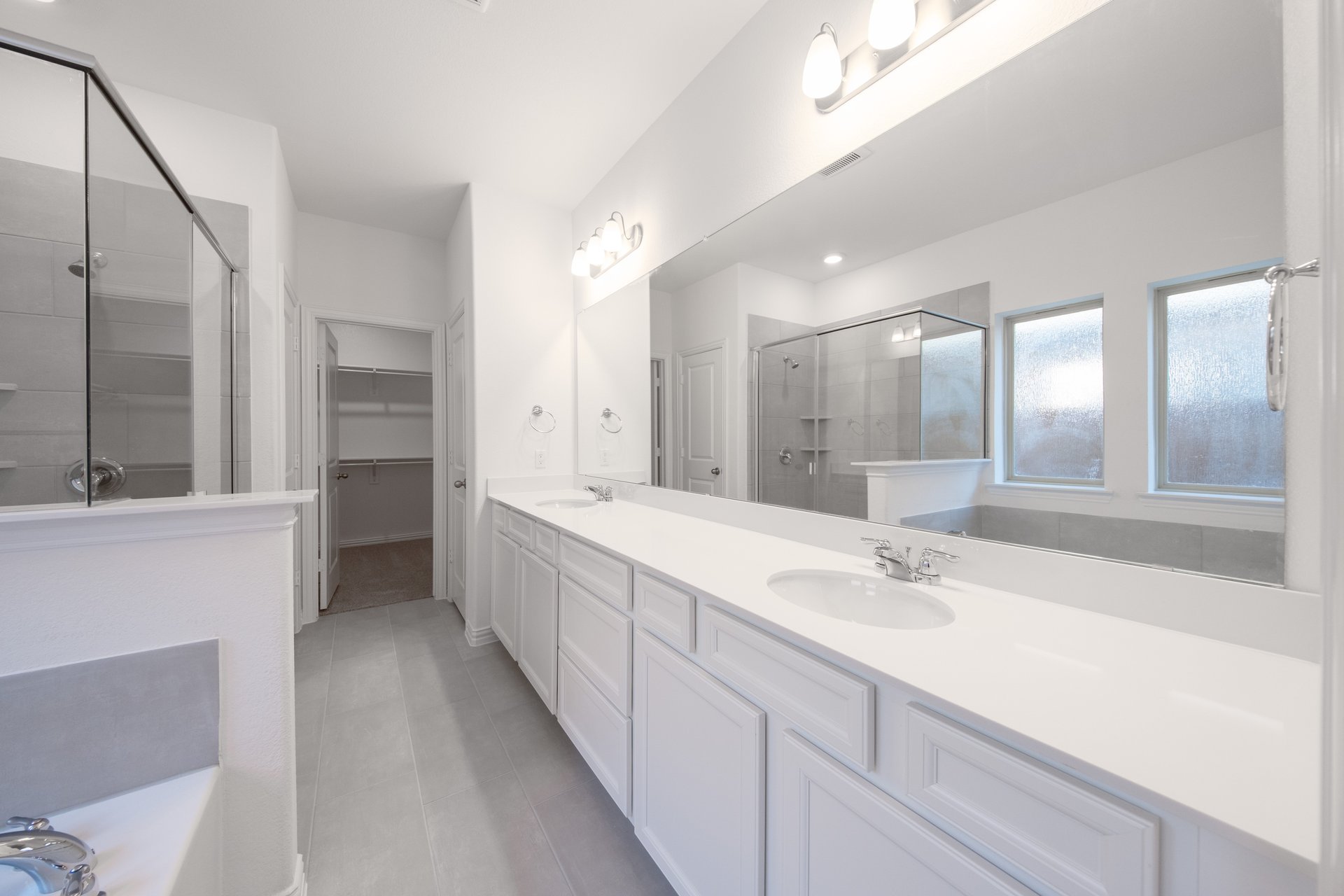 bathroom with large mirror and white countertops 
