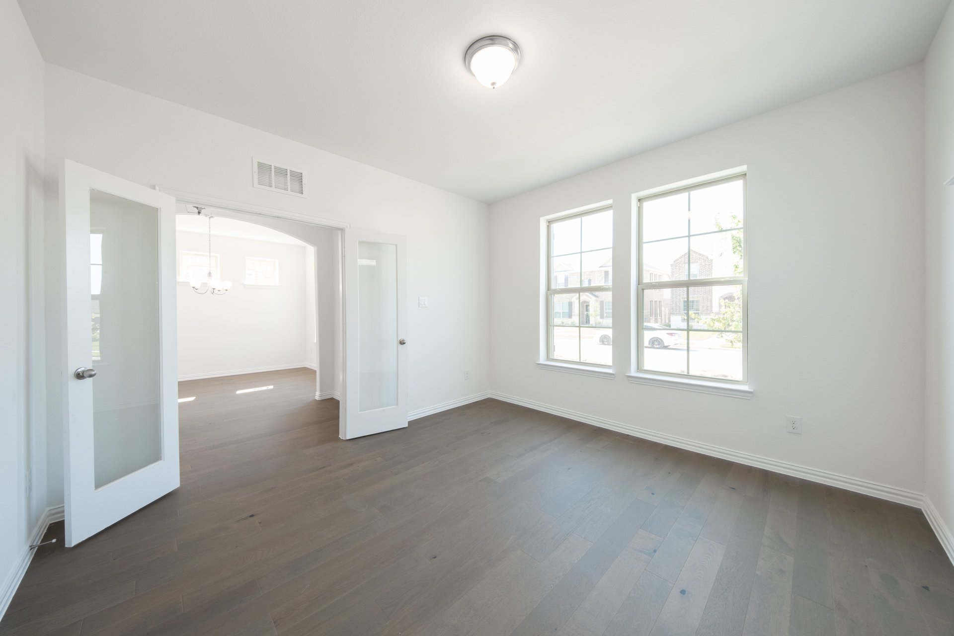 study with wood flooring and windows 