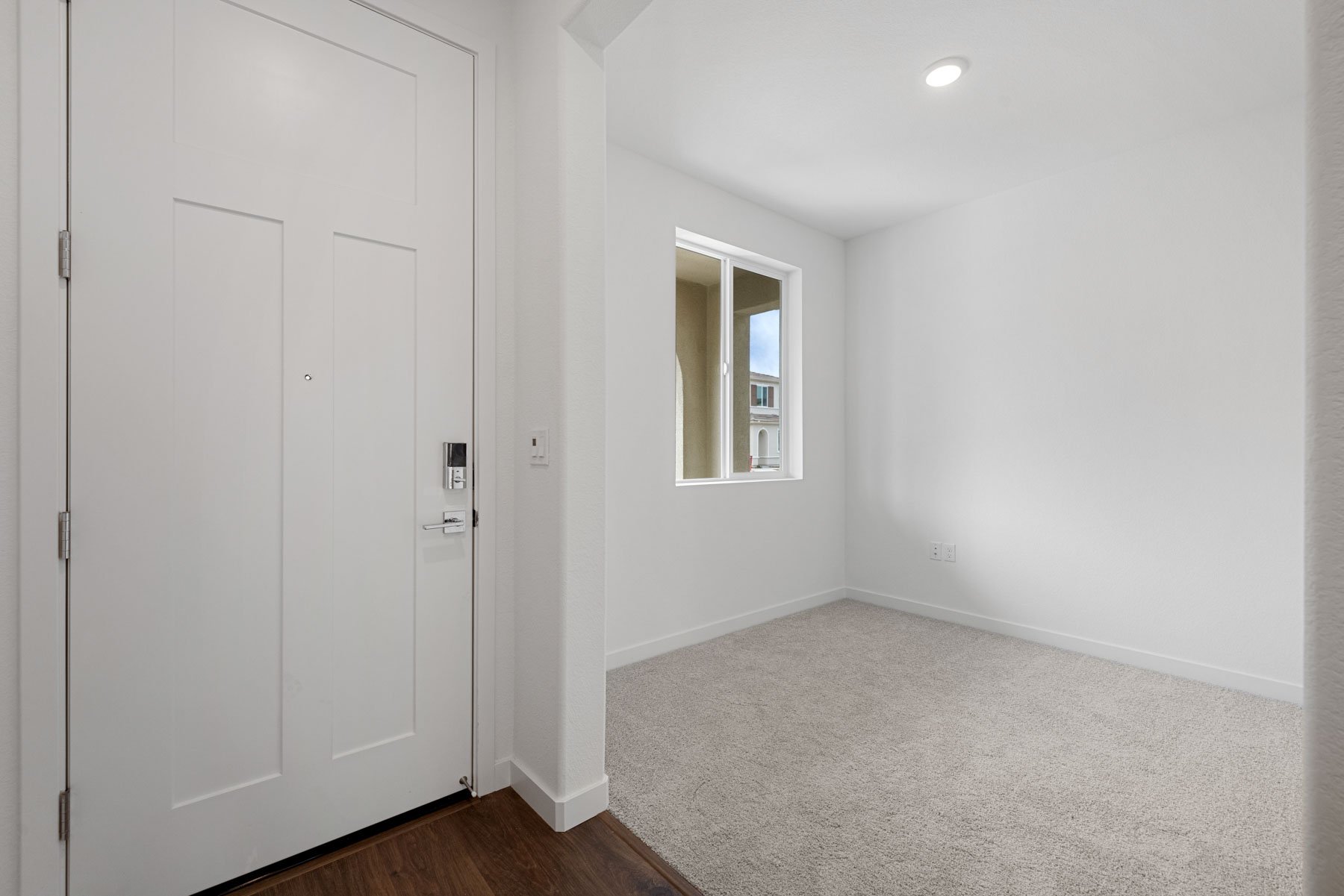 study off entry foyer with light tan carpet white walls and window