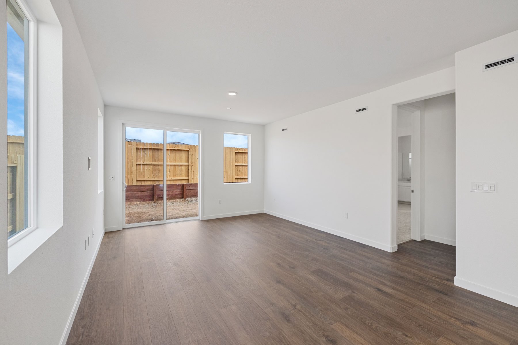 great room with wood floors, white walls, and multiple windows