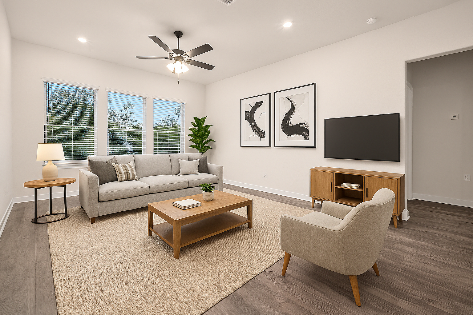 great room with brown flooring, windows & a ceiling fan