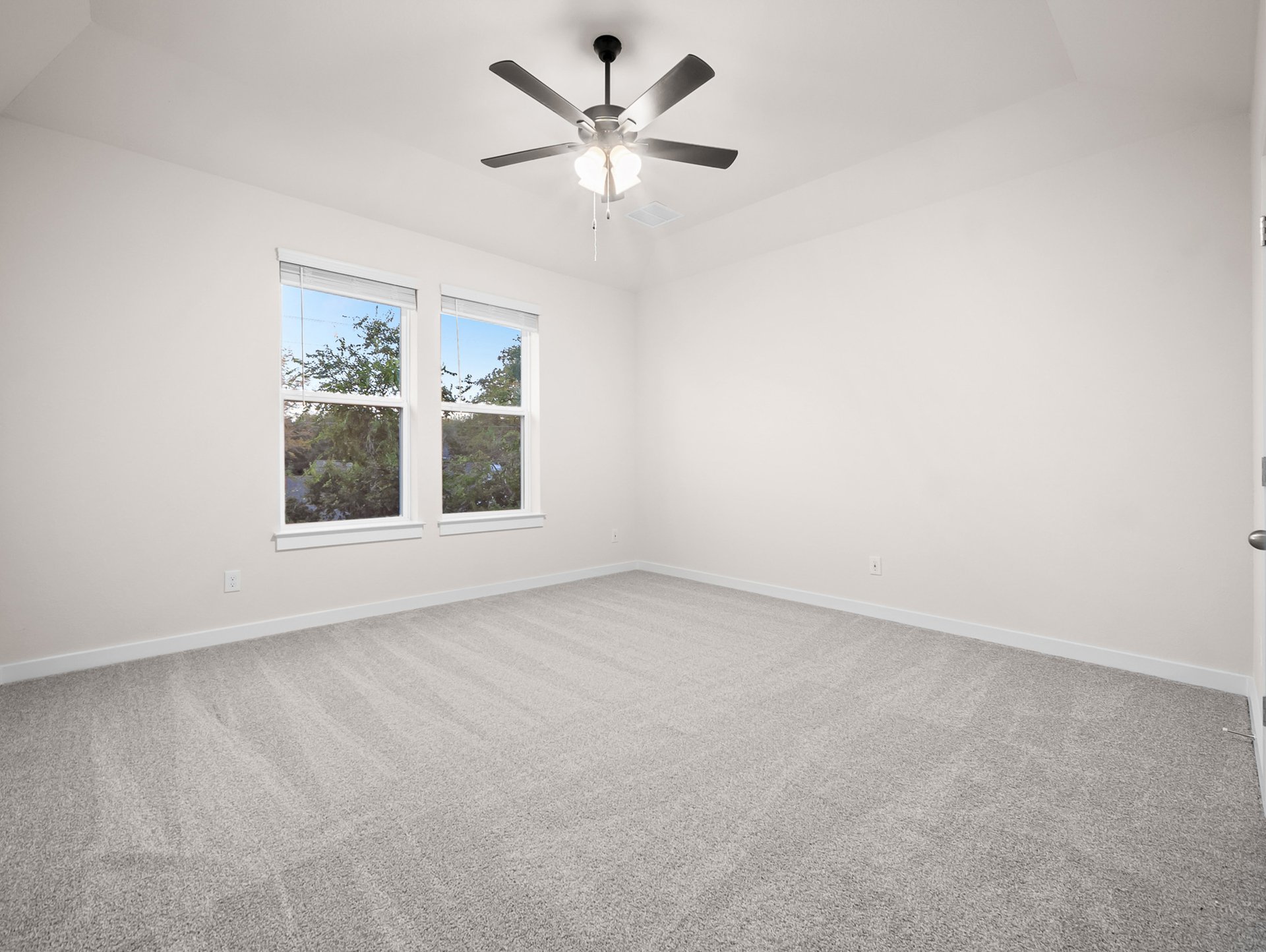 bedroom with carpet, windows & a ceiling fan