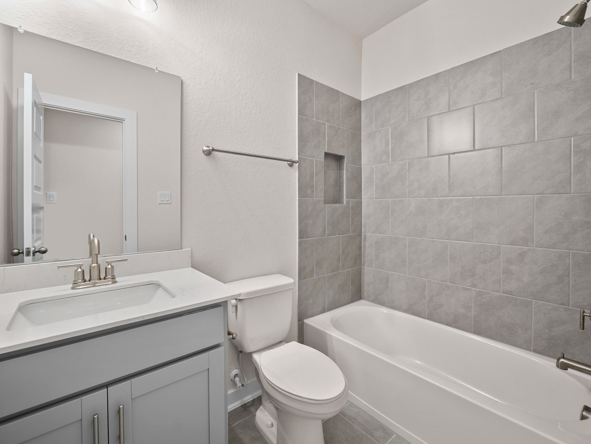 bathroom with soaking tub, quartz countertops & a sink