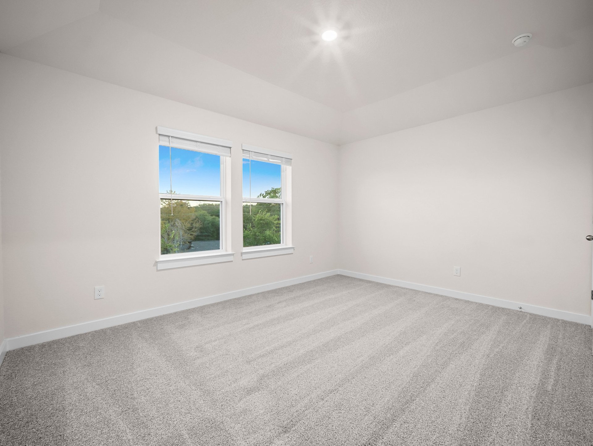 bedroom with carpet, windows & a sloped ceiling