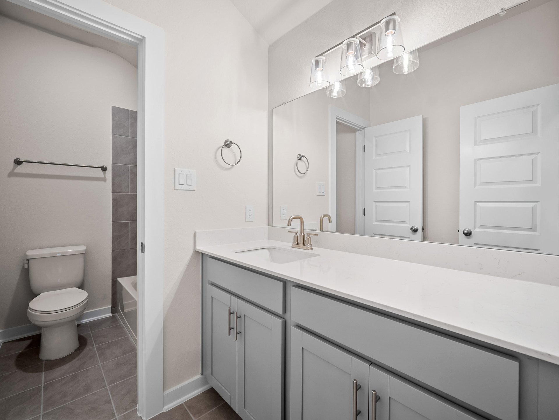 bathroom with soaking tub, quartz countertops & a sink
