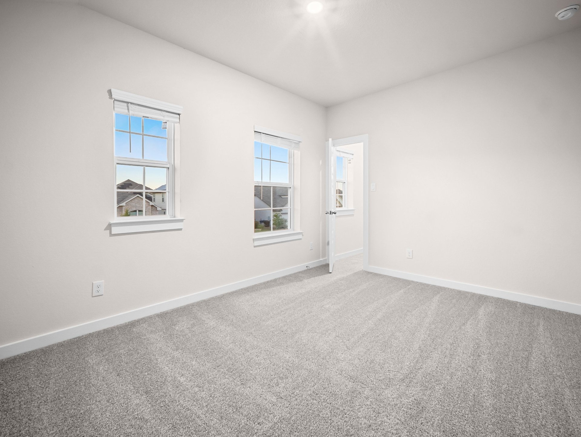 bedroom with carpet, windows & a sloped ceiling