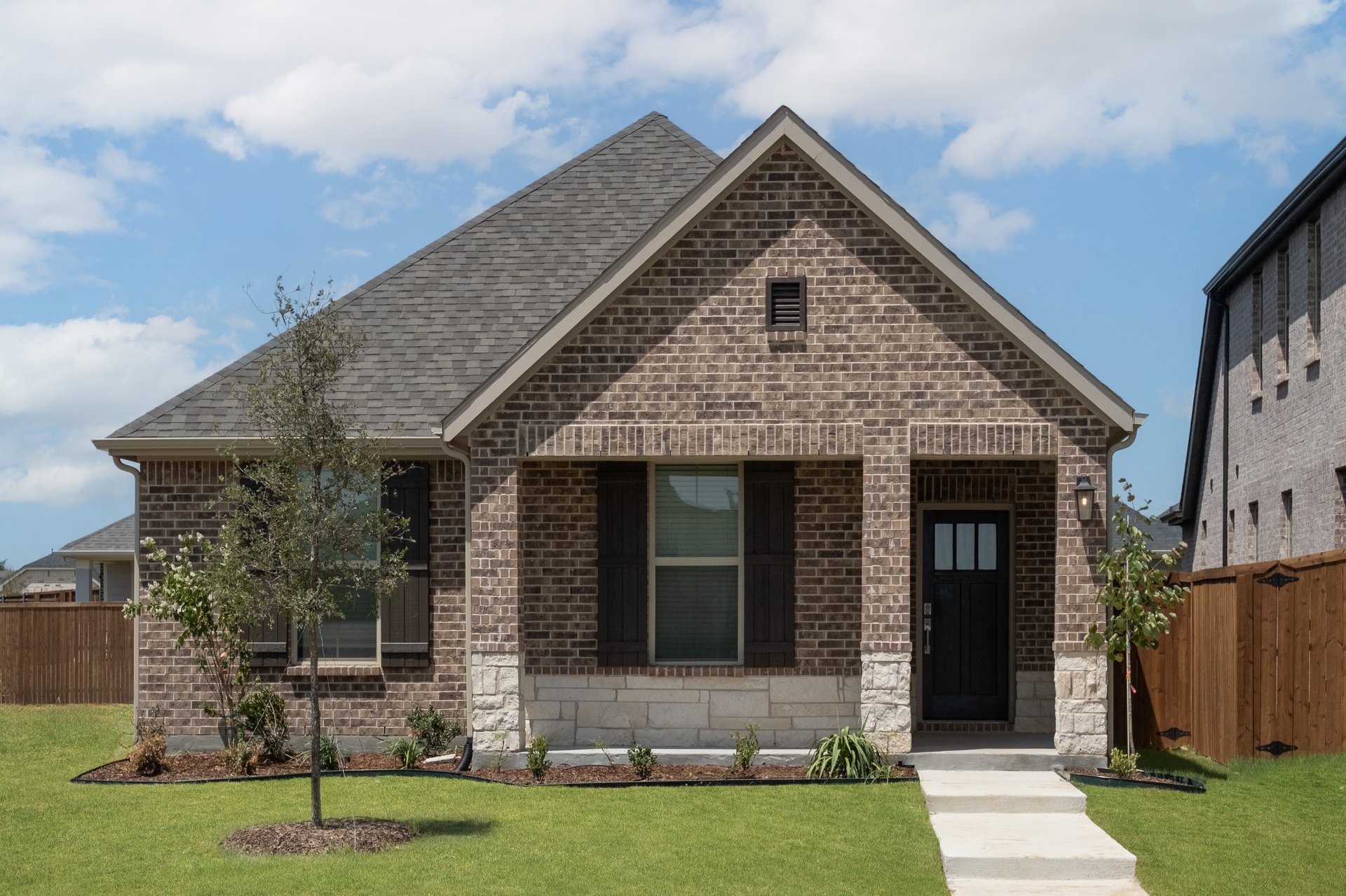 exterior of home with brown brick and white stone