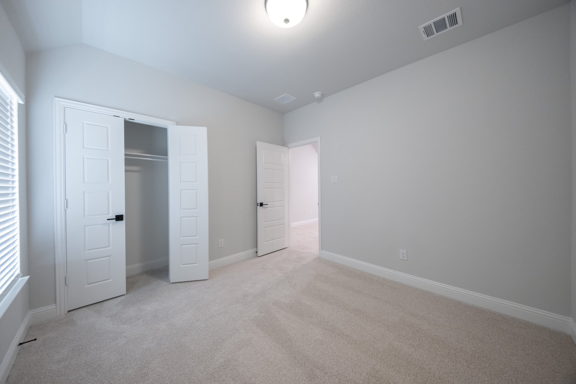 guest bedroom with carpet and walk-in closet