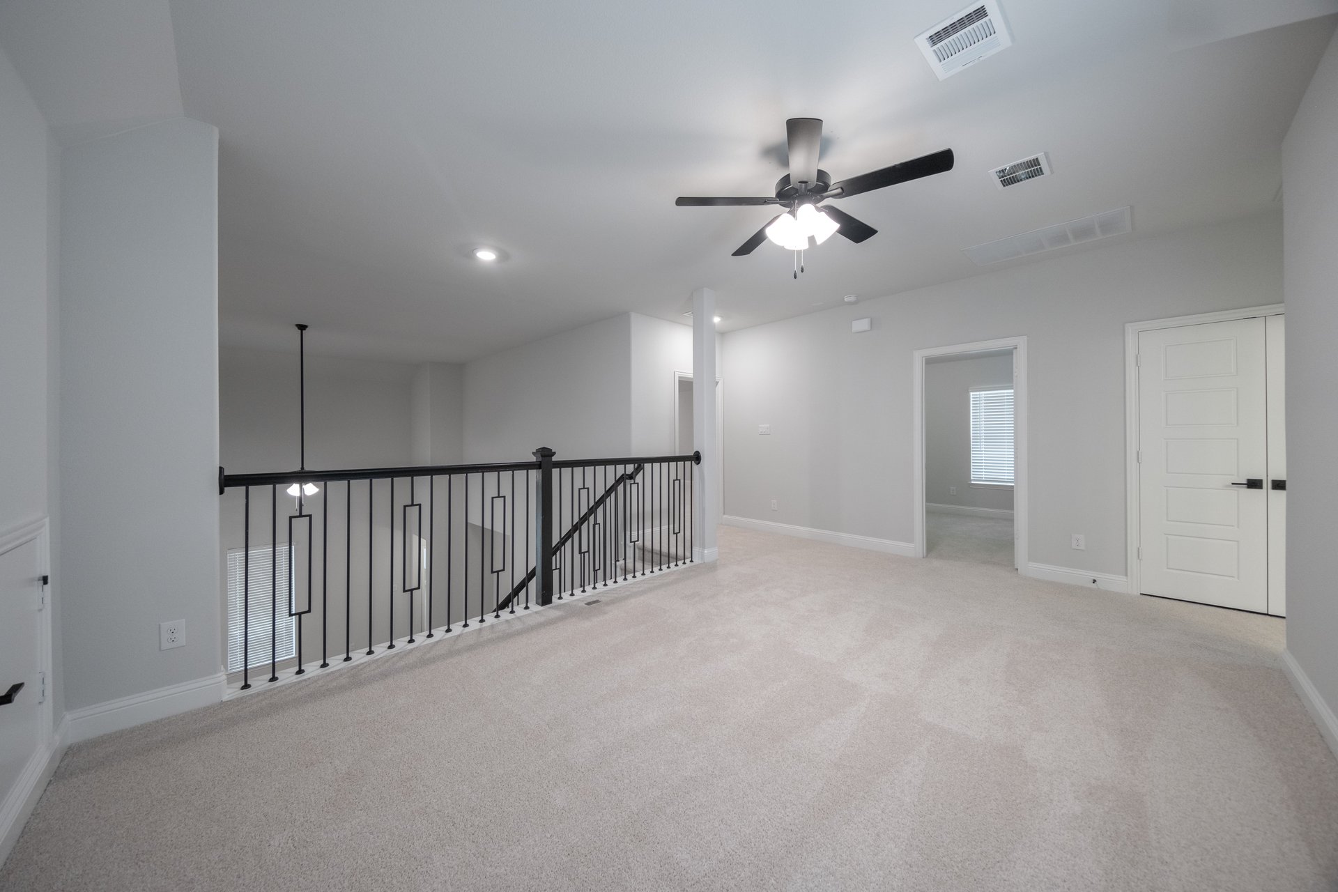 spacious game room with carpet and ceiling fan