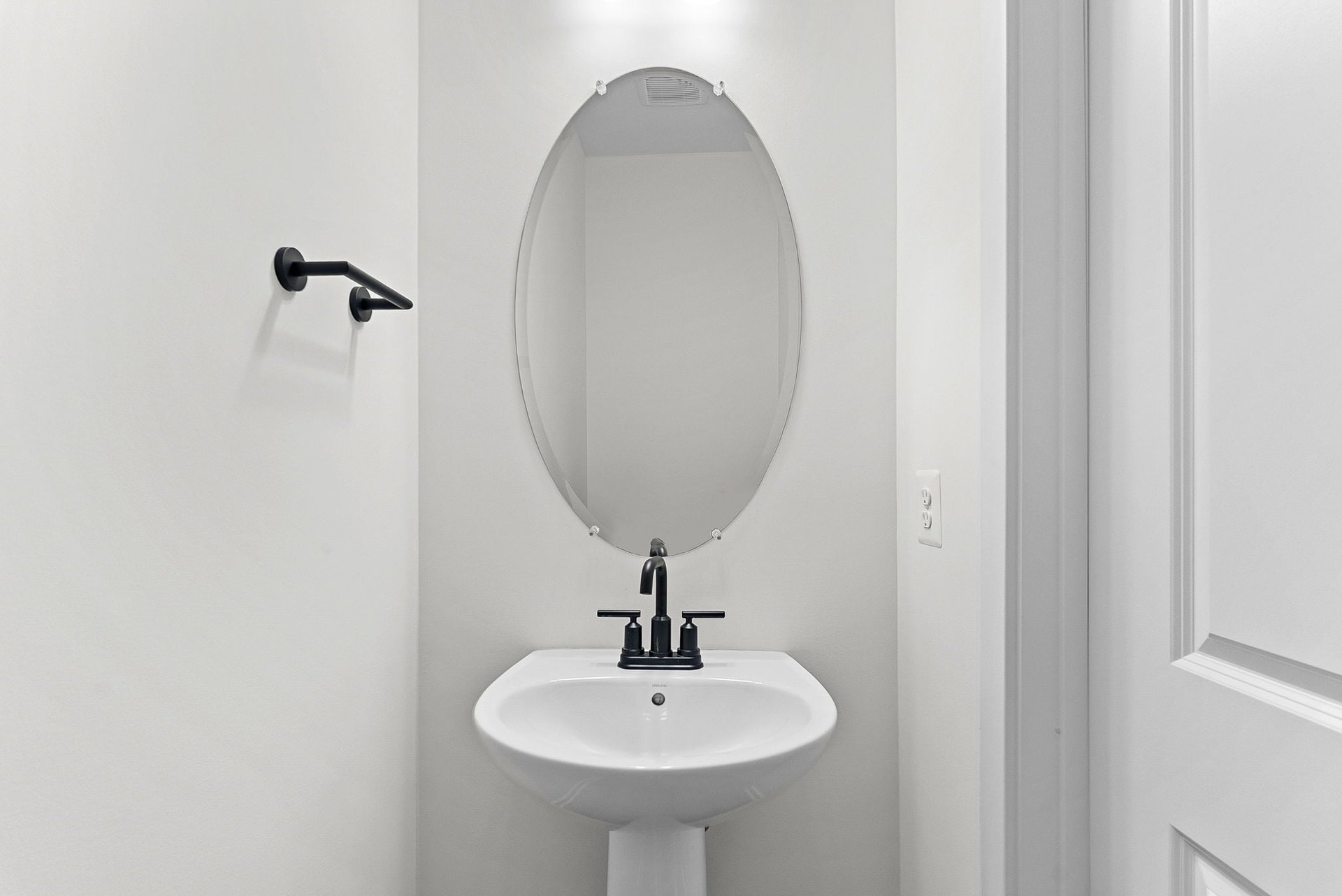 powder room with an oval mirror