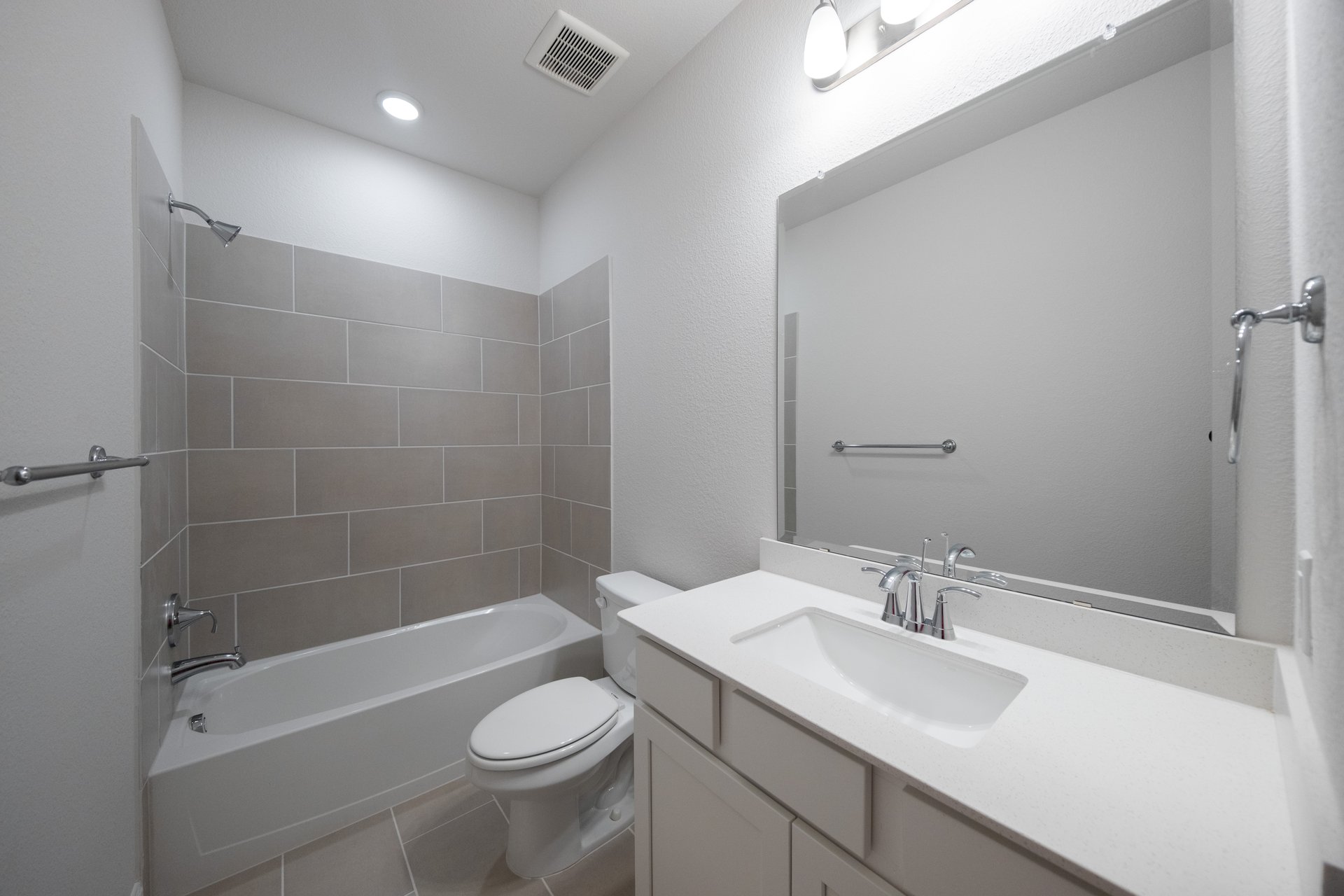 bathroom with white countertops and tile 